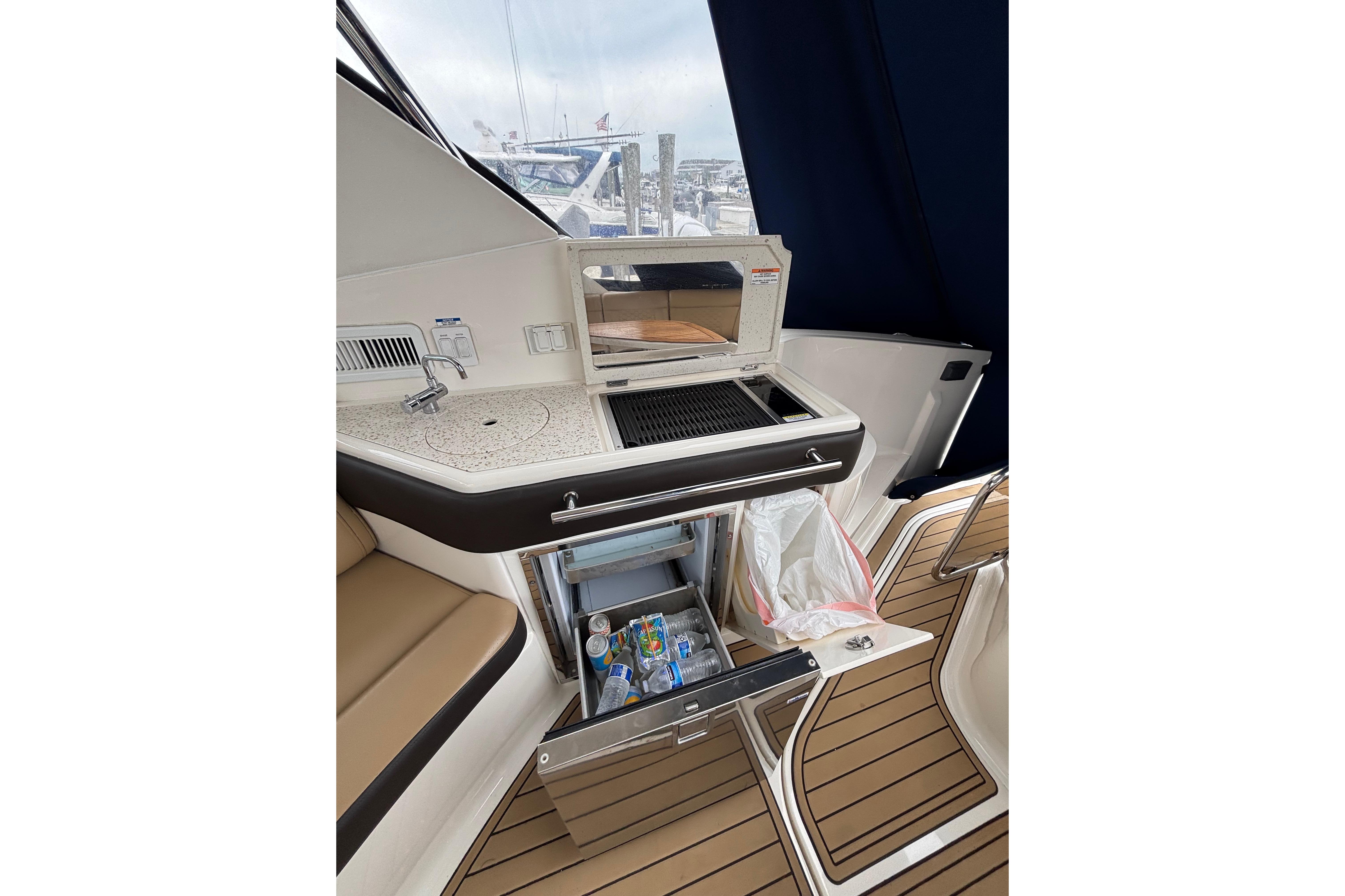 2021 Sea Ray Sundancer 320 Outboard interior with kitchenette and seating area.