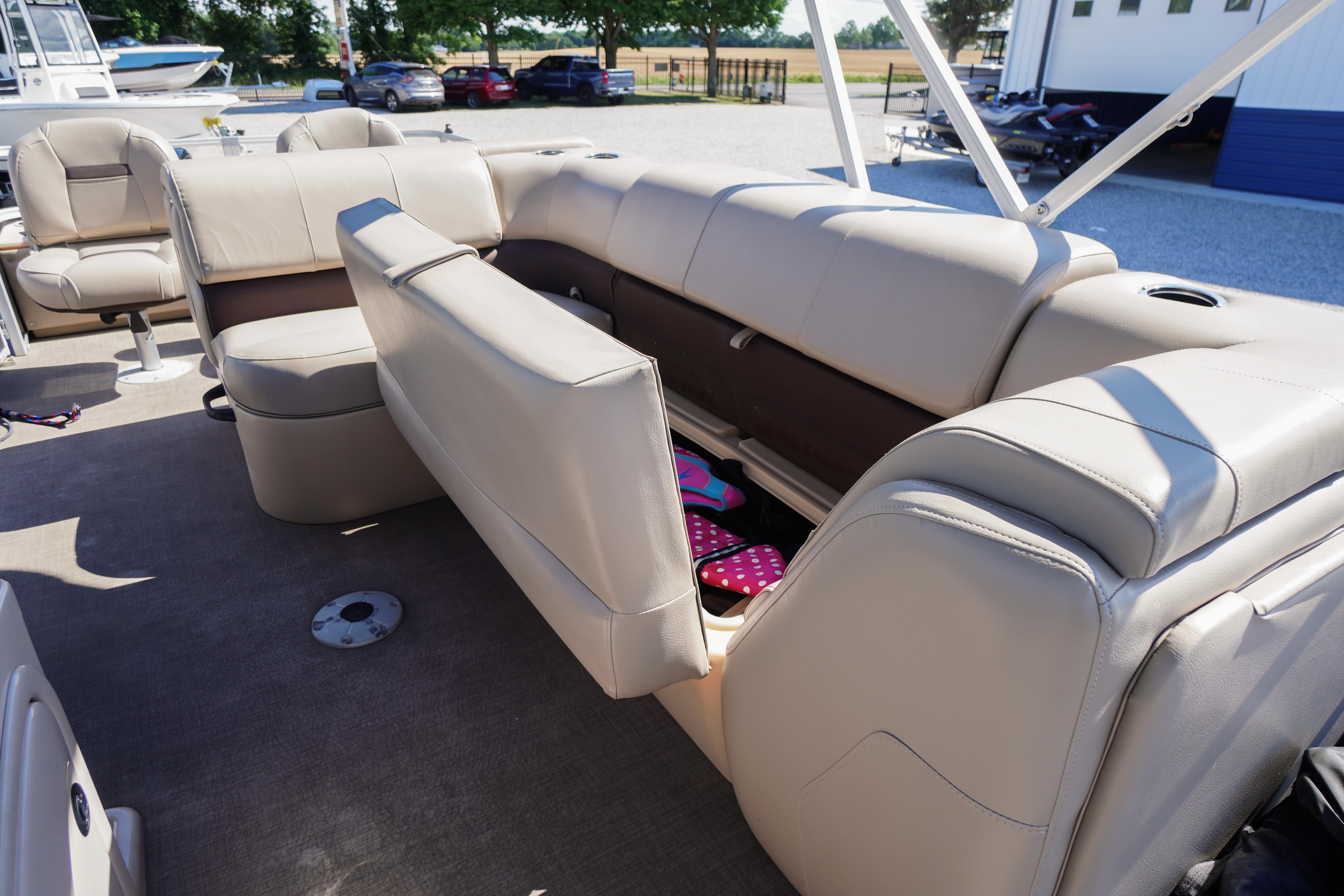 2019 SUNTRACKER Fishin' Barge 22 DLX interior with beige seating and storage compartment.