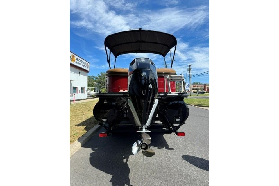 2026 Regency 230 DL boat with outboard motor, parked near service center.