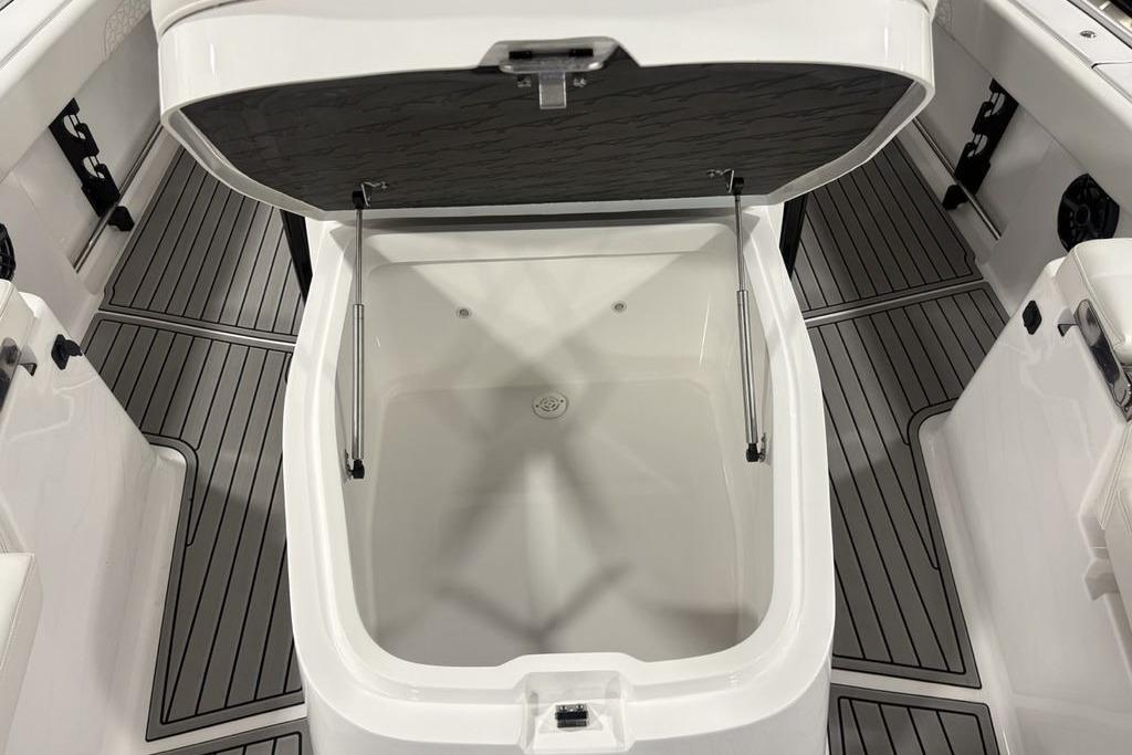 Open storage compartment on 2026 Tidewater 3100 Carolina Bay boat, featuring sleek interior design.