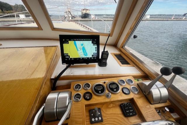 1989 Duffy Wilbur 42 Flybridge Cruiser helm with navigation system and controls, docked by the water.