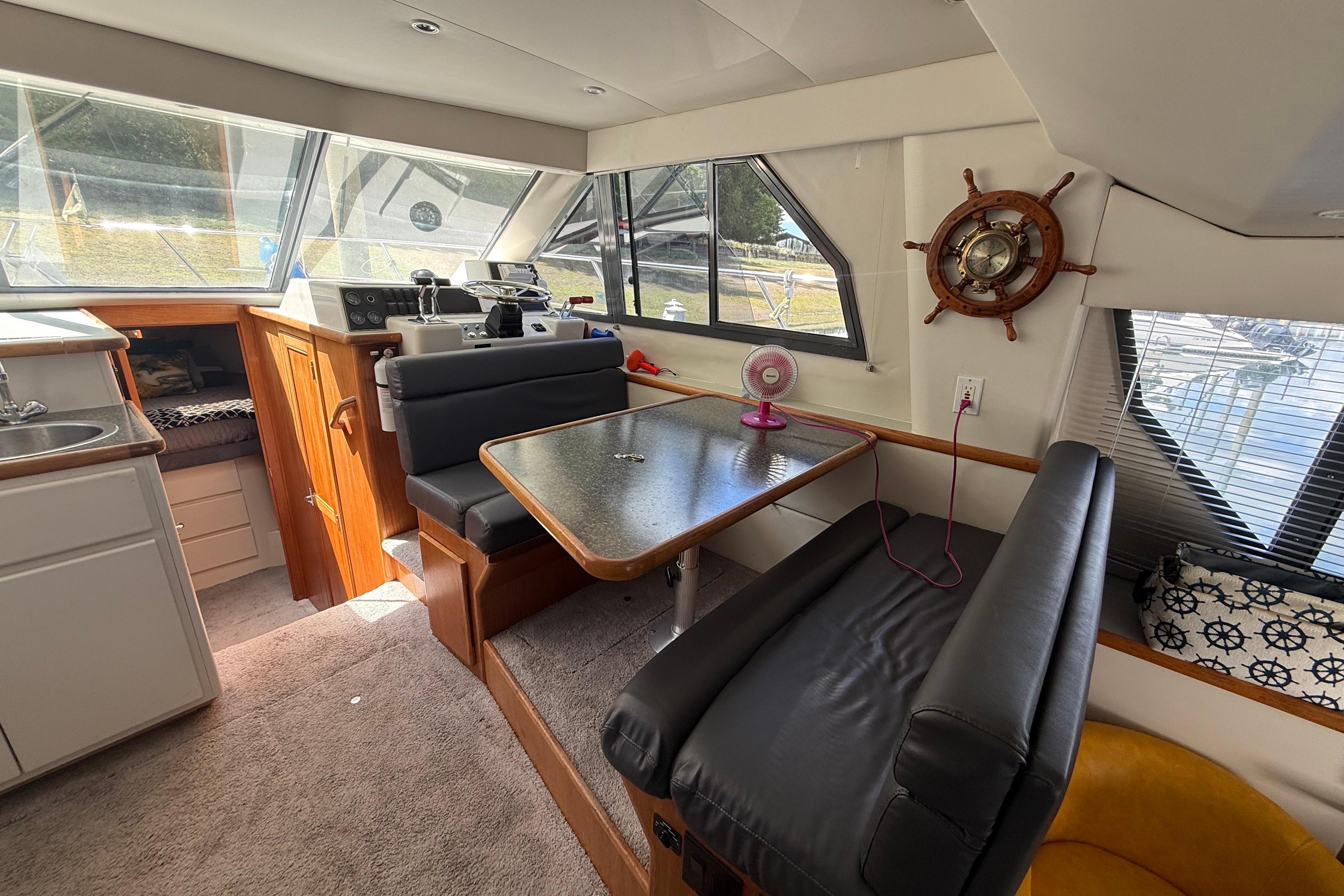 Interior of a 1995 Carver 370 Voyager yacht with dining area and helm.