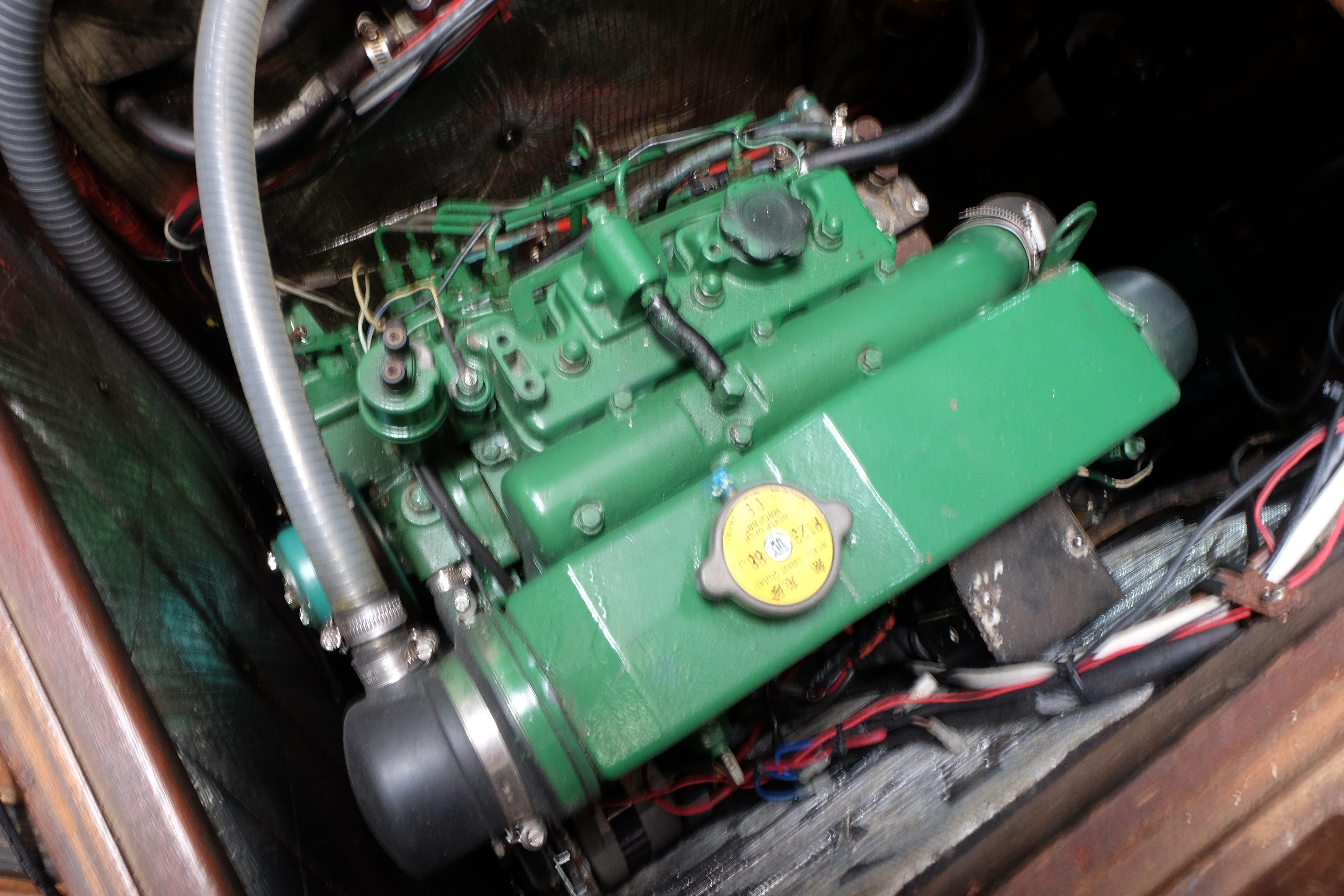 Green engine of a 1979 Westwind 35 boat, featuring hoses and wiring.