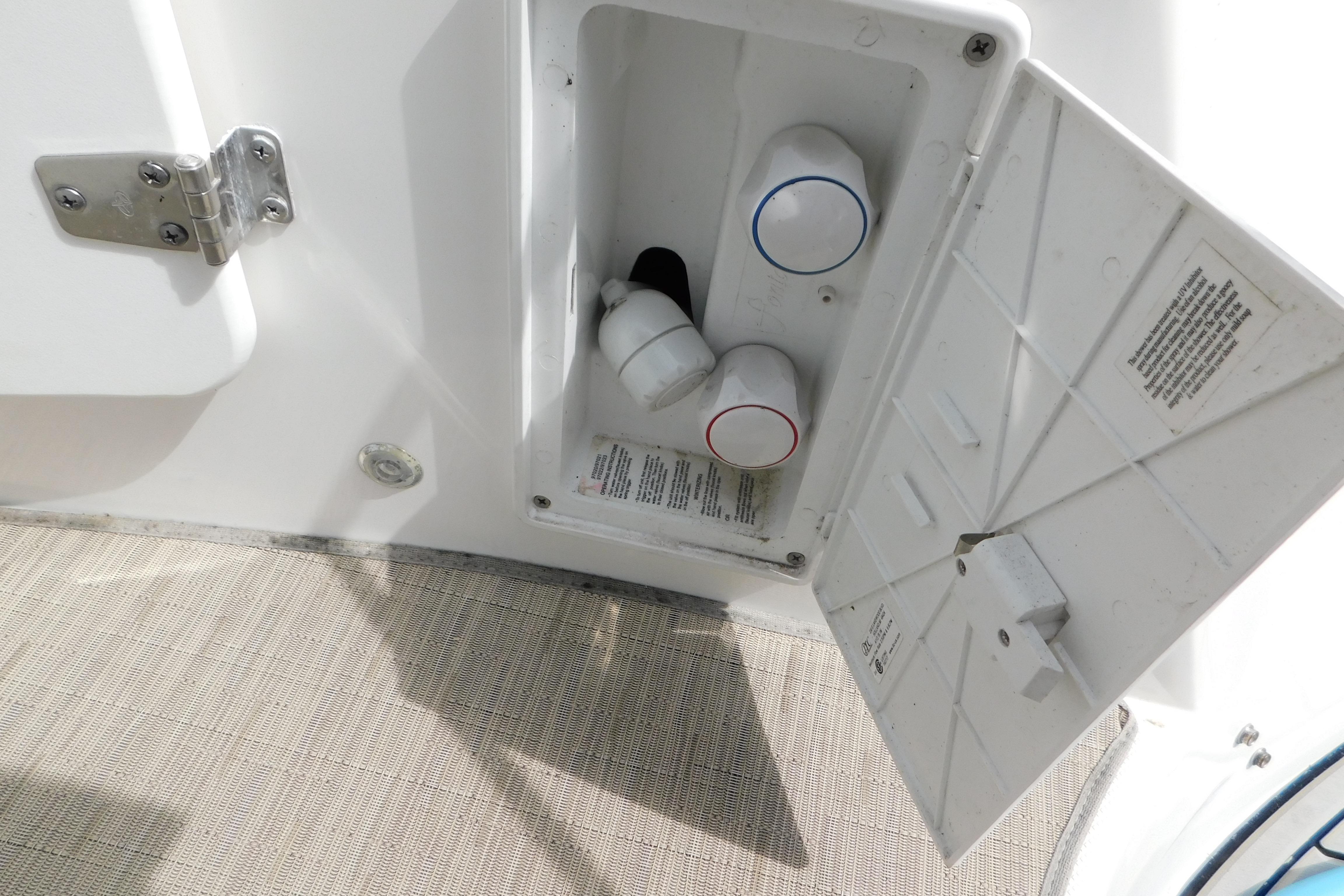 2017 Rinker EX 320 boat shower controls with open access panel on deck.