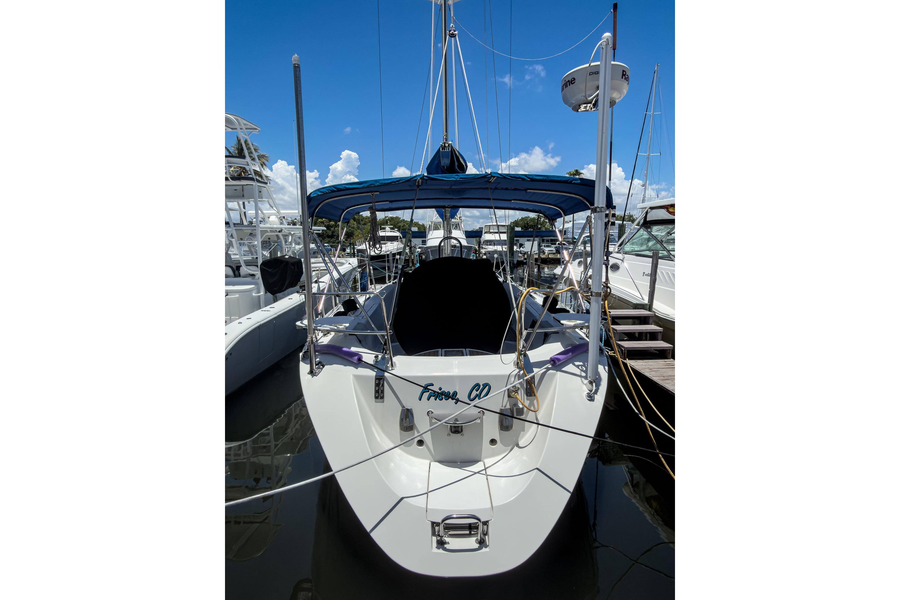 Beneteau First 38 s5 sailboat, 1993 model, docked at marina under clear blue sky.