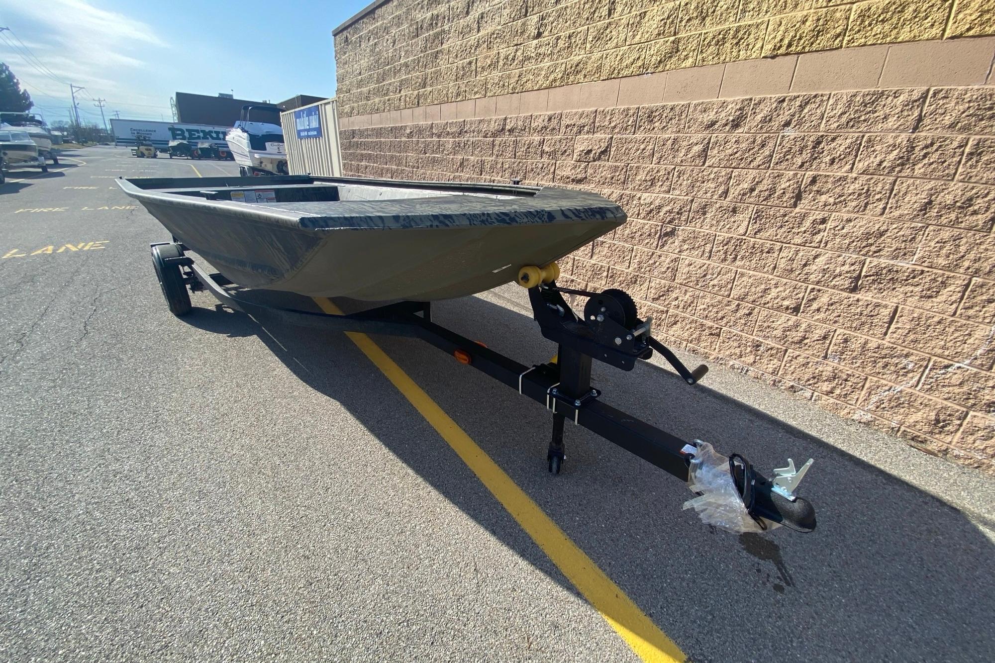 2026 Tracker Grizzly 1648 Utility boat on trailer, parked beside a brick wall.