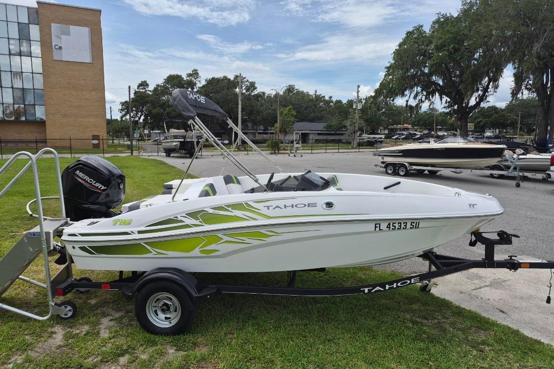 2021 Tahoe T16 boat on trailer with Mercury engine, parked outdoors.