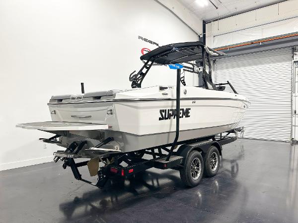 2025 Supreme S240 boat on trailer in showroom, featuring sleek design and modern features.