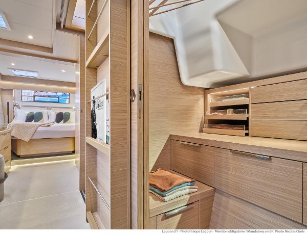 Luxurious interior of 2025 Lagoon 51 ICONIC yacht, featuring modern bedroom and storage space.