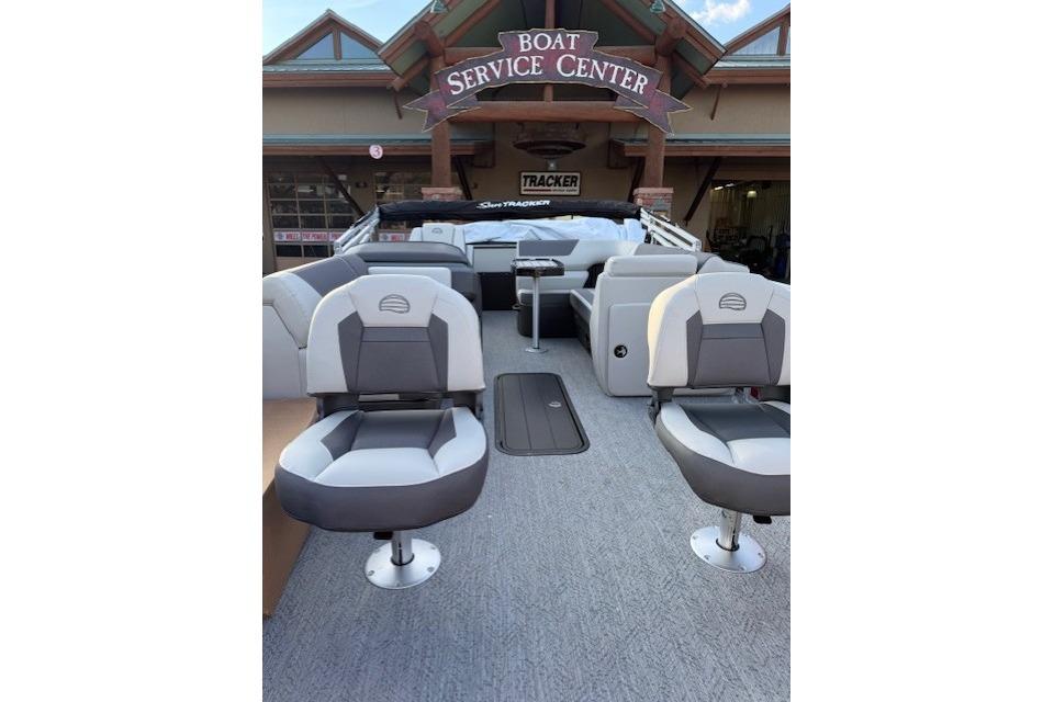 2026 Sun Tracker Fishin' Barge 22 XP3 at boat service center, featuring comfortable seating.