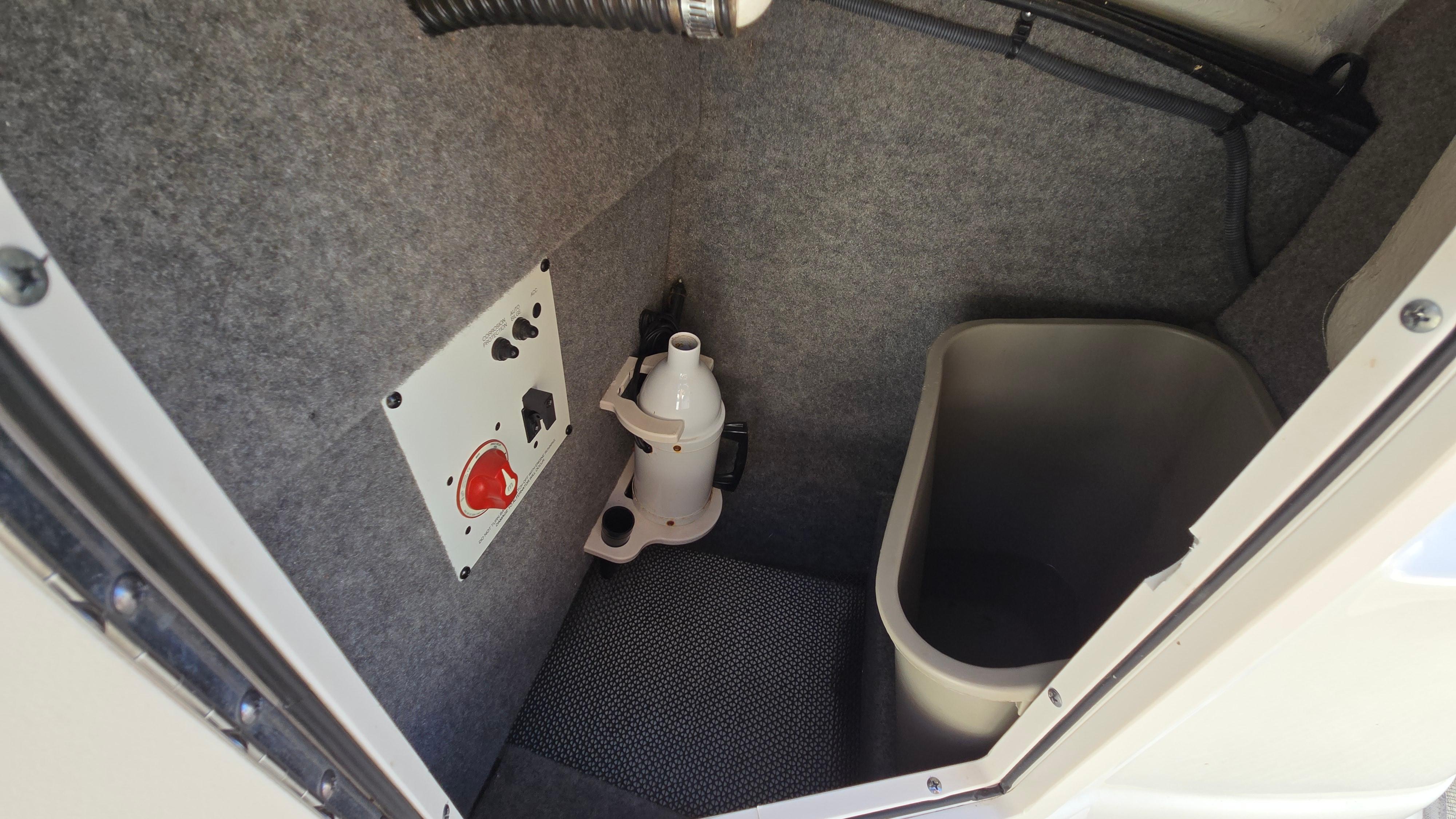 2018 Chaparral 224 Sunesta boat interior storage compartment with utility panel and container.