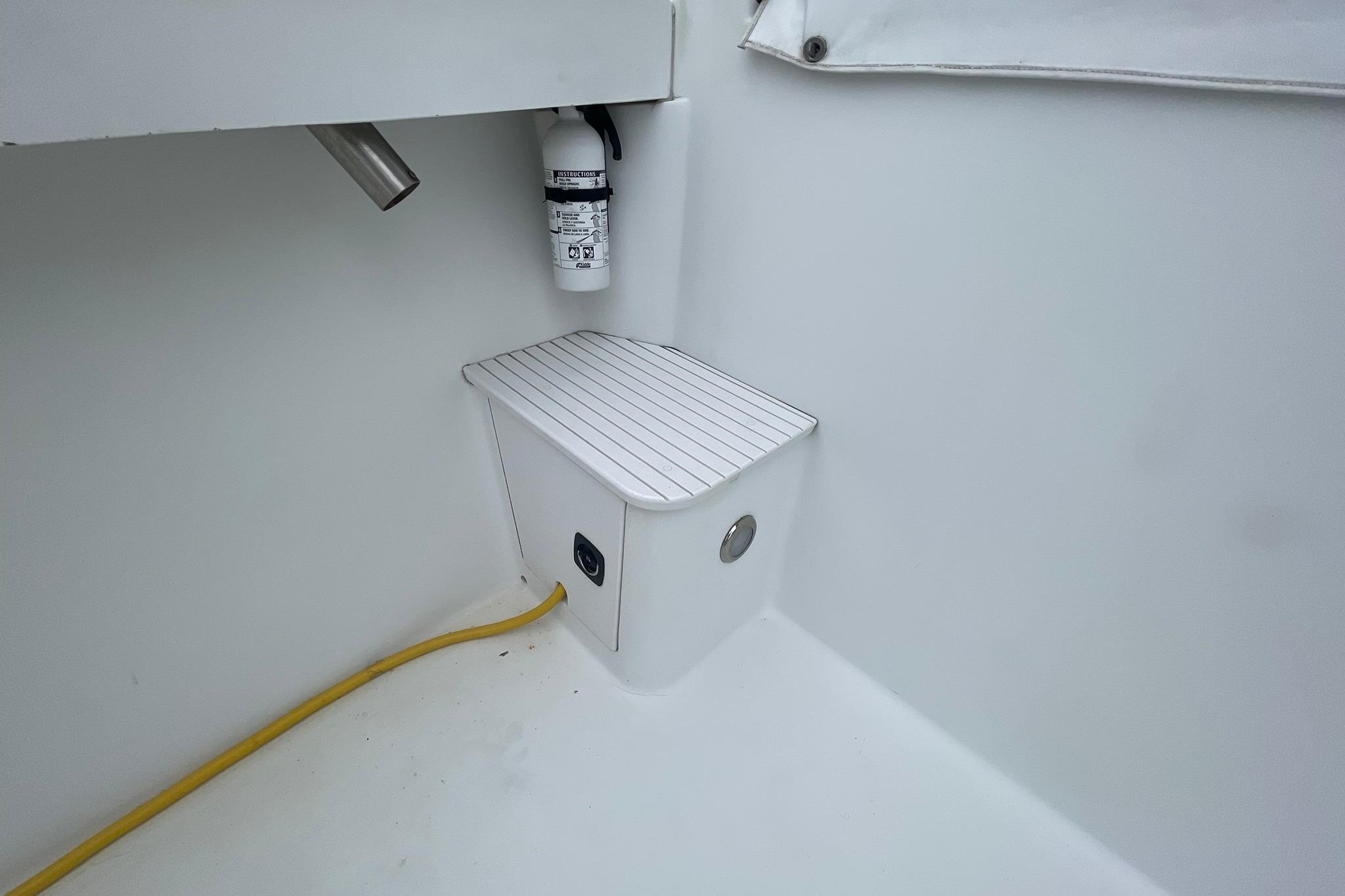 1996 Luhrs Tournament 290 Open boat interior with fire extinguisher and electrical outlet.