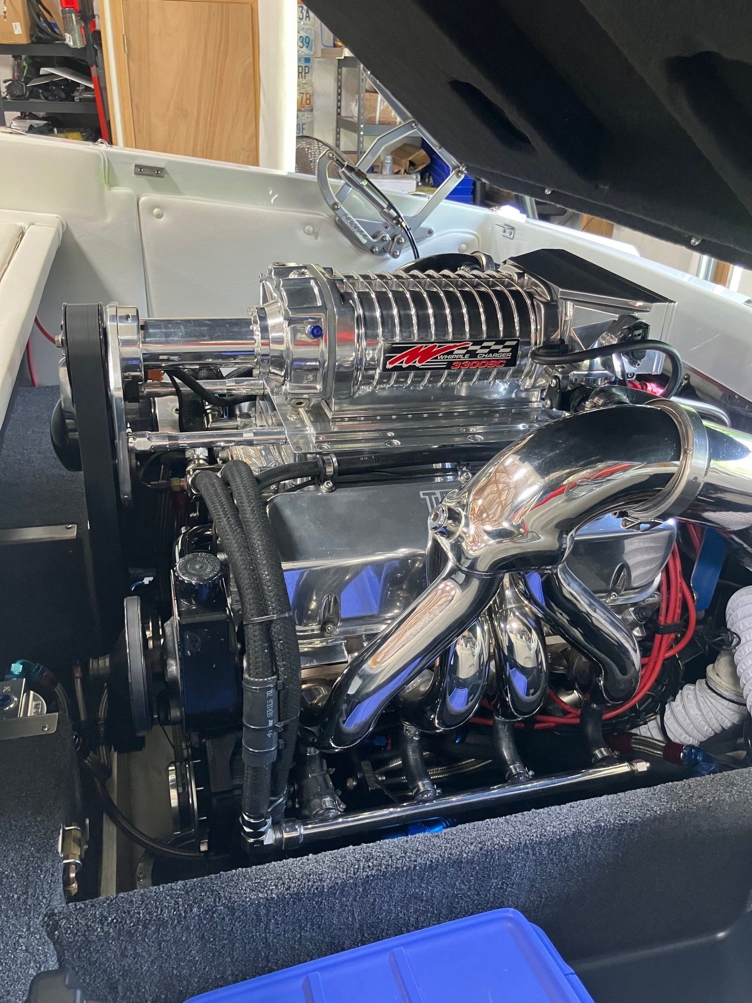 A shiny engine with chrome parts inside a boat.