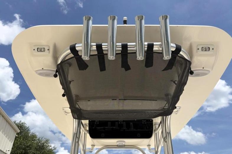 2023 Key West 203 FS boat top view with rod holders and canopy against blue sky.
