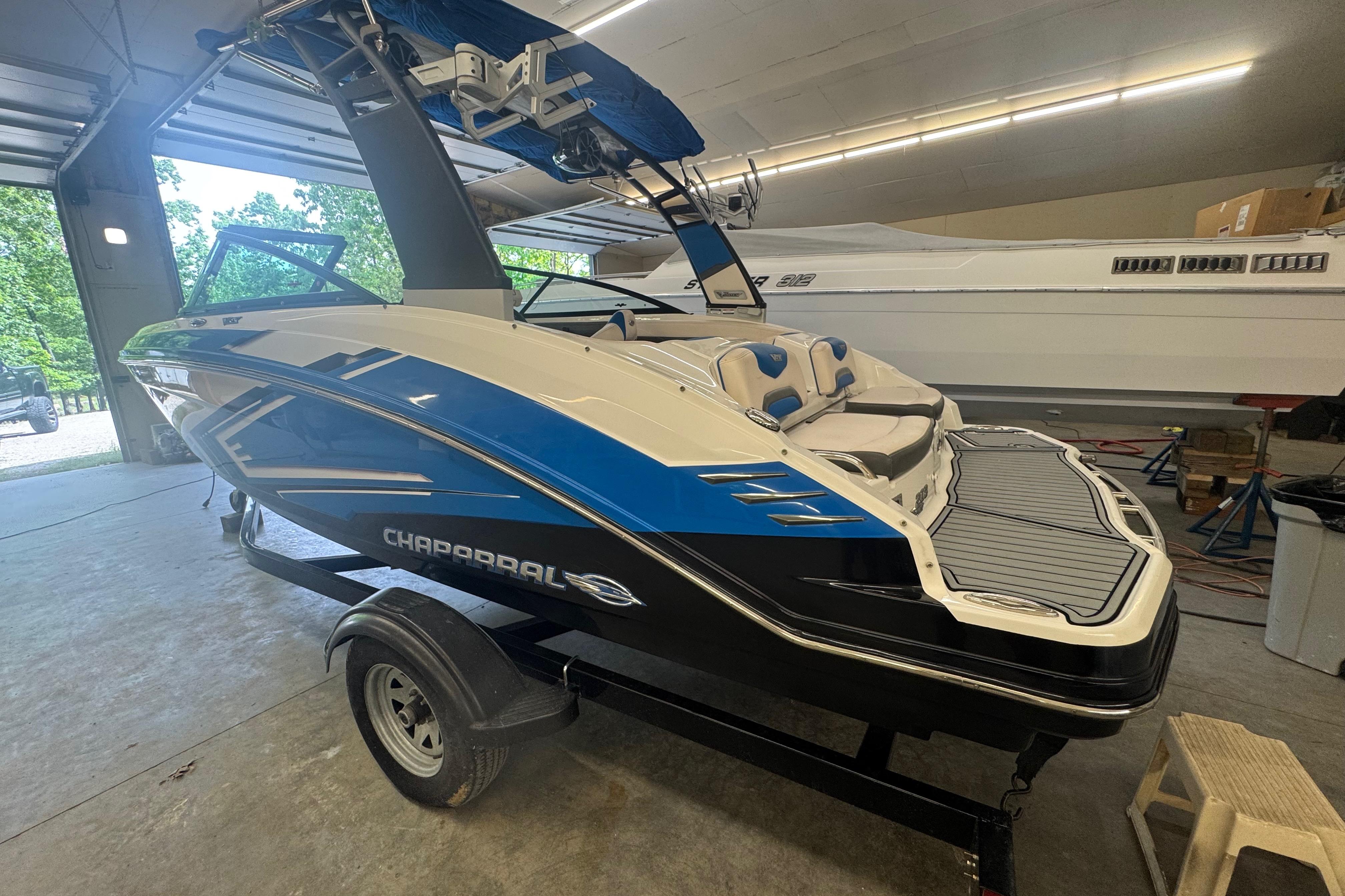 2017 Chaparral Vortex 203 VRX boat in a garage, showcasing sleek design and vibrant colors.