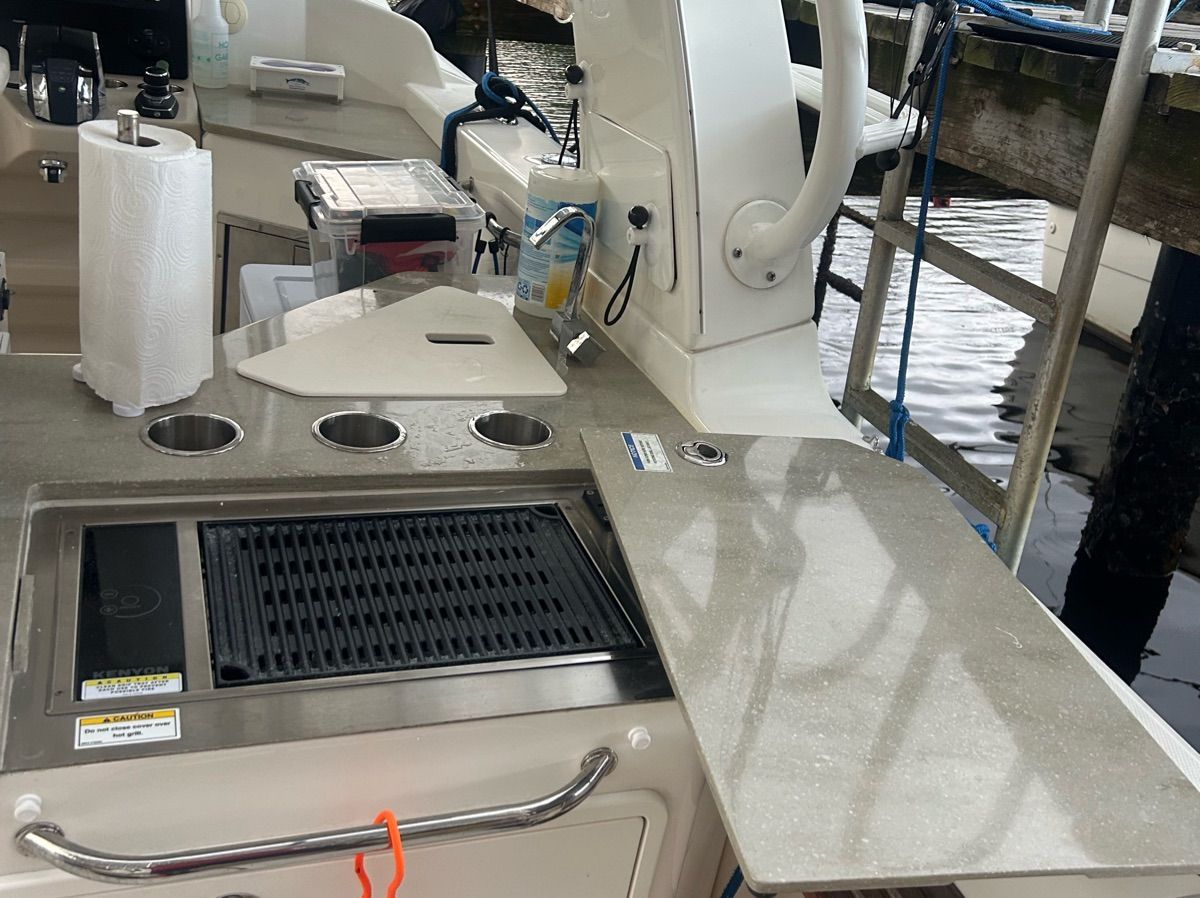 The 2021 Boston Whaler 350 Realm features a well-equipped outdoor kitchen with a grill and sink.