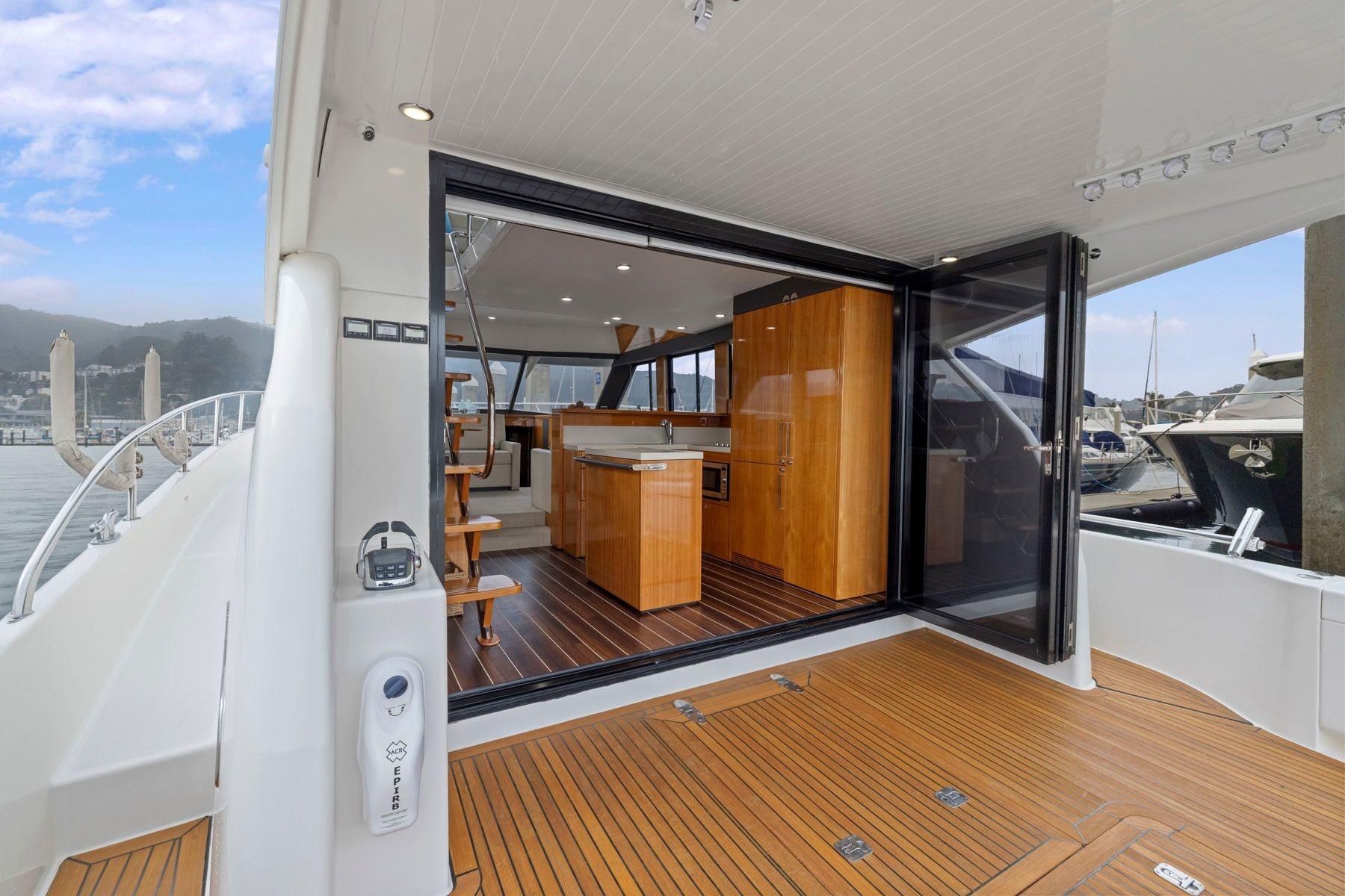 2014 Maritimo M50 yacht interior with open sliding doors and wooden flooring.