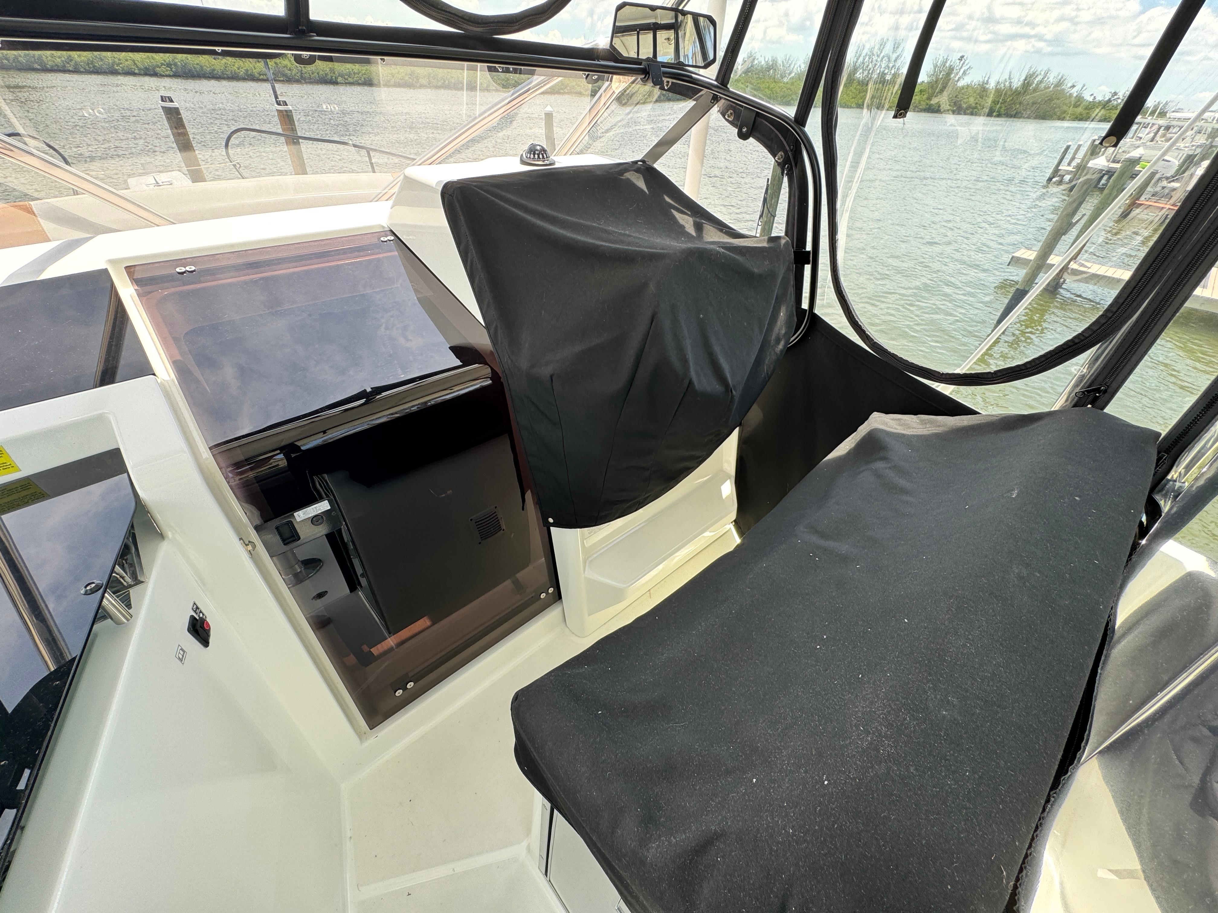 2022 Beneteau Flyer 9 SUNdeck cockpit with covered seating and helm, near water.