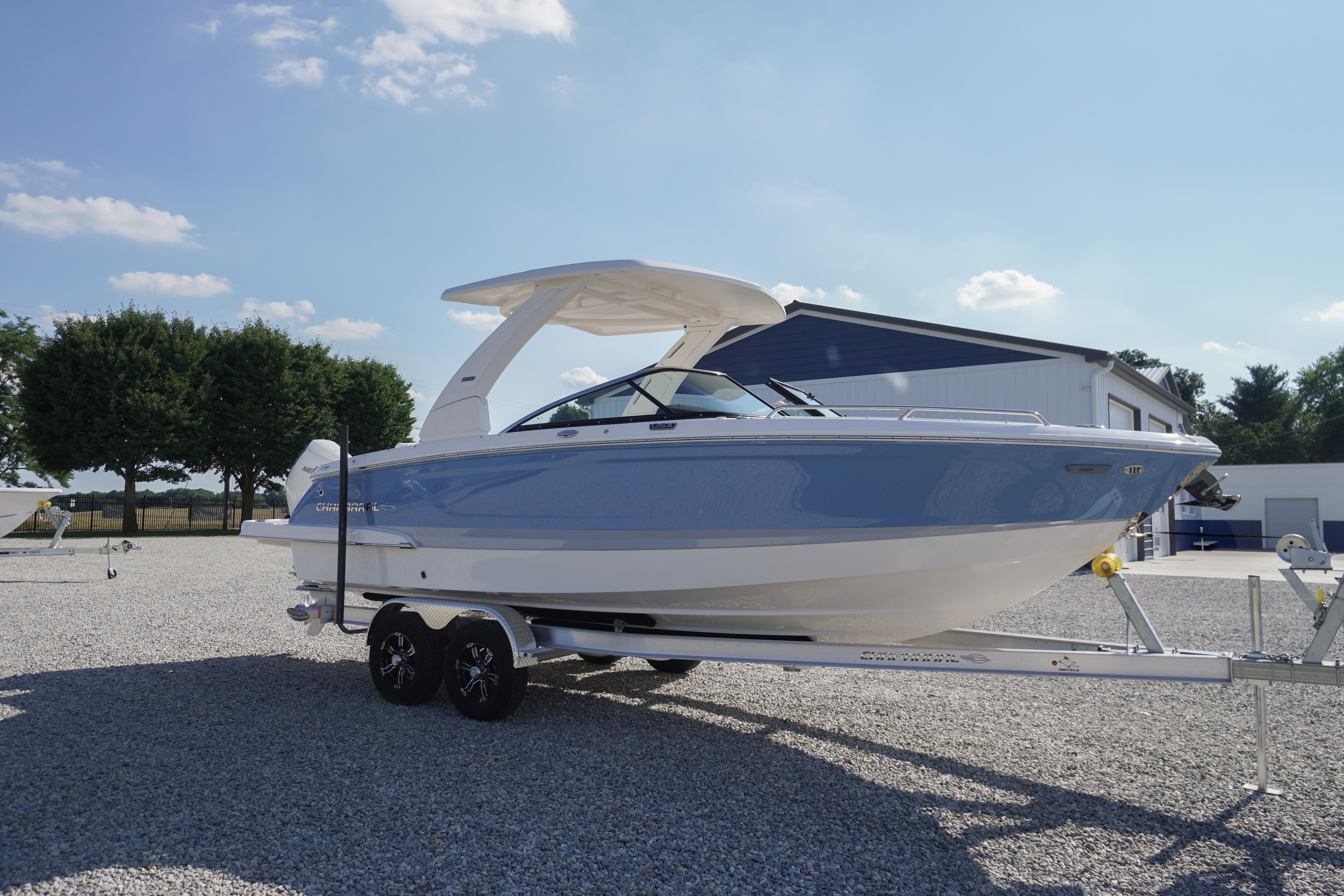 2026 Chaparral 270 OSX boat on trailer, parked outdoors under clear sky.