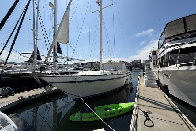 1982 Lancer 45 Motorsailer docked at marina with kayak nearby.