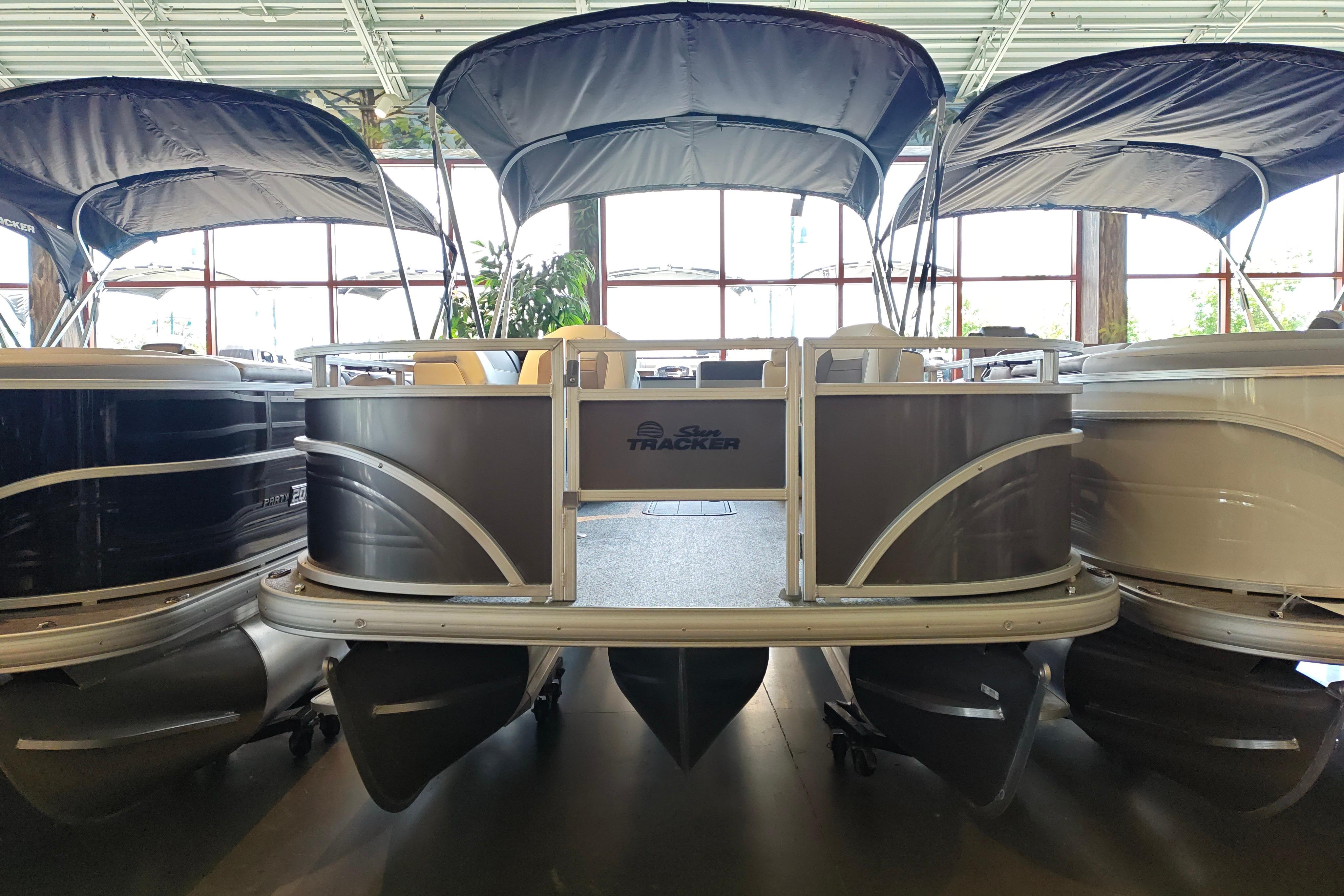 2026 Sun Tracker Fishin' Barge 22 XP3 pontoon boat displayed in showroom.