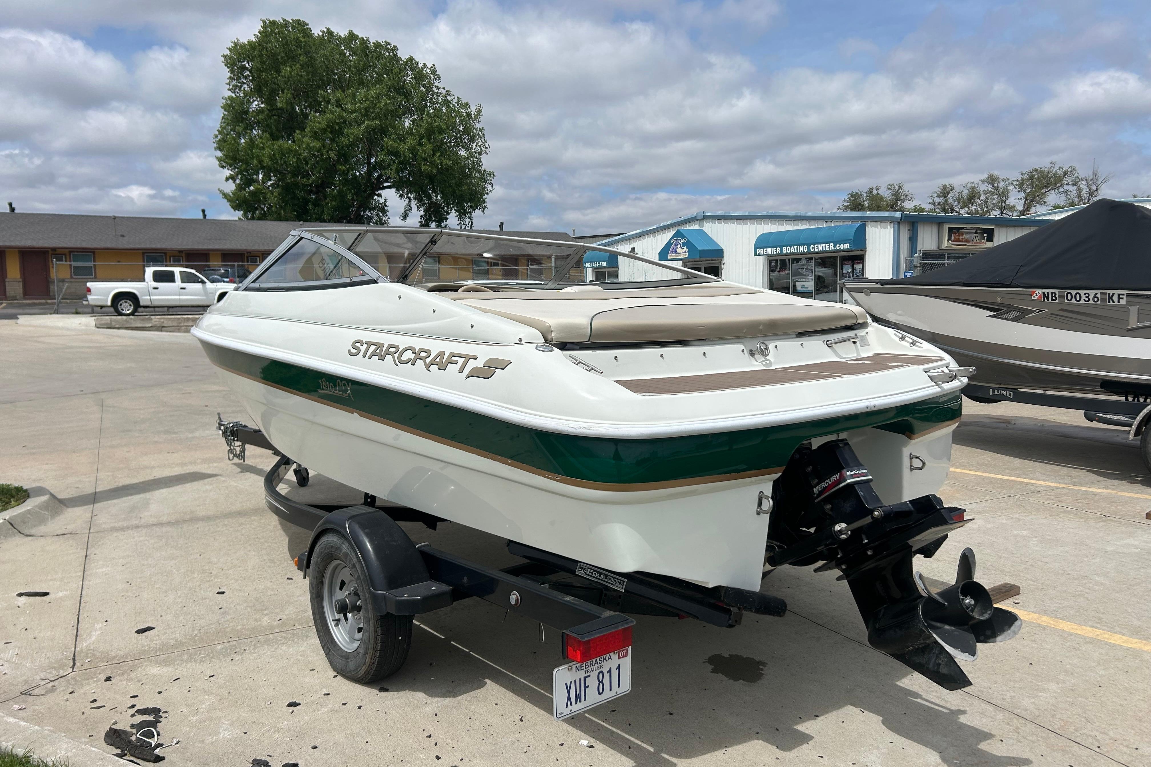 2000 Starcraft 1810 boat on trailer in parking lot, under cloudy sky.