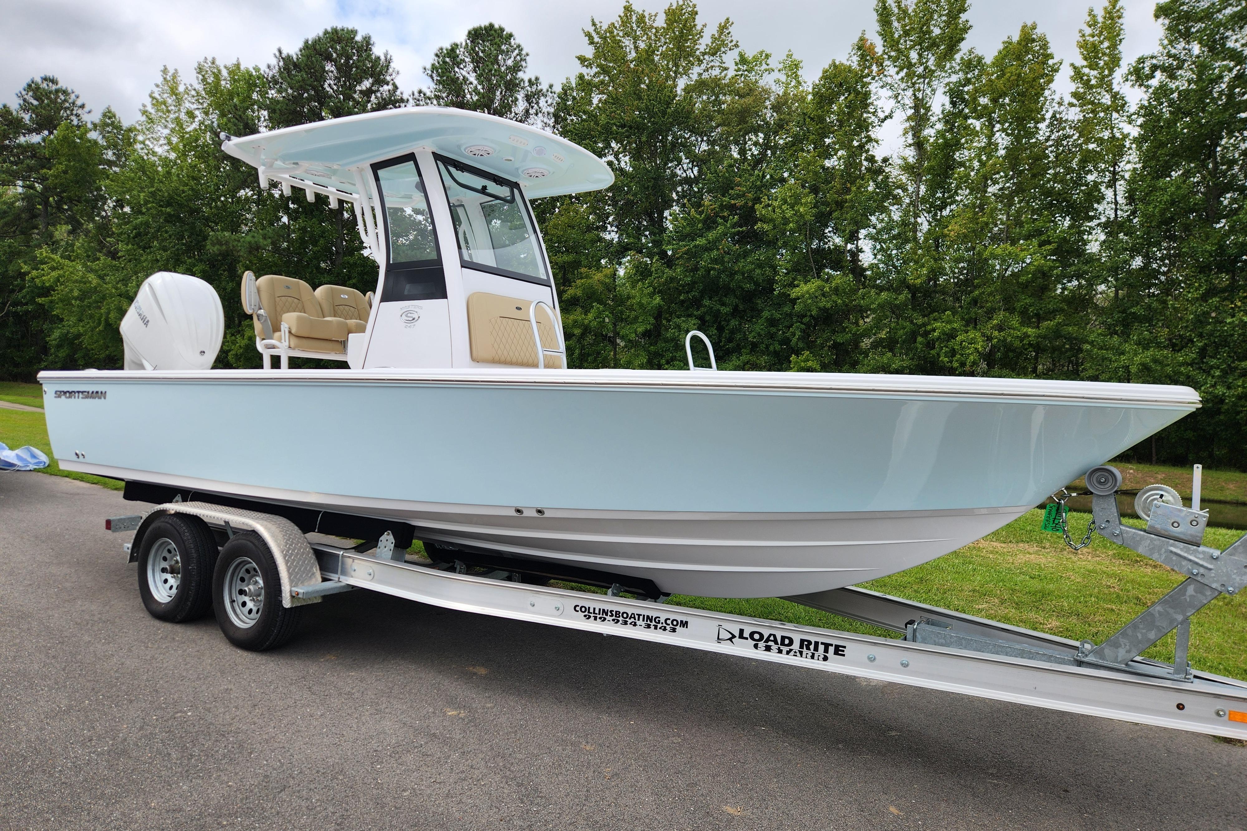 2026 Sportsman Masters 247 Bay Boat on trailer, parked outdoors with trees in background.