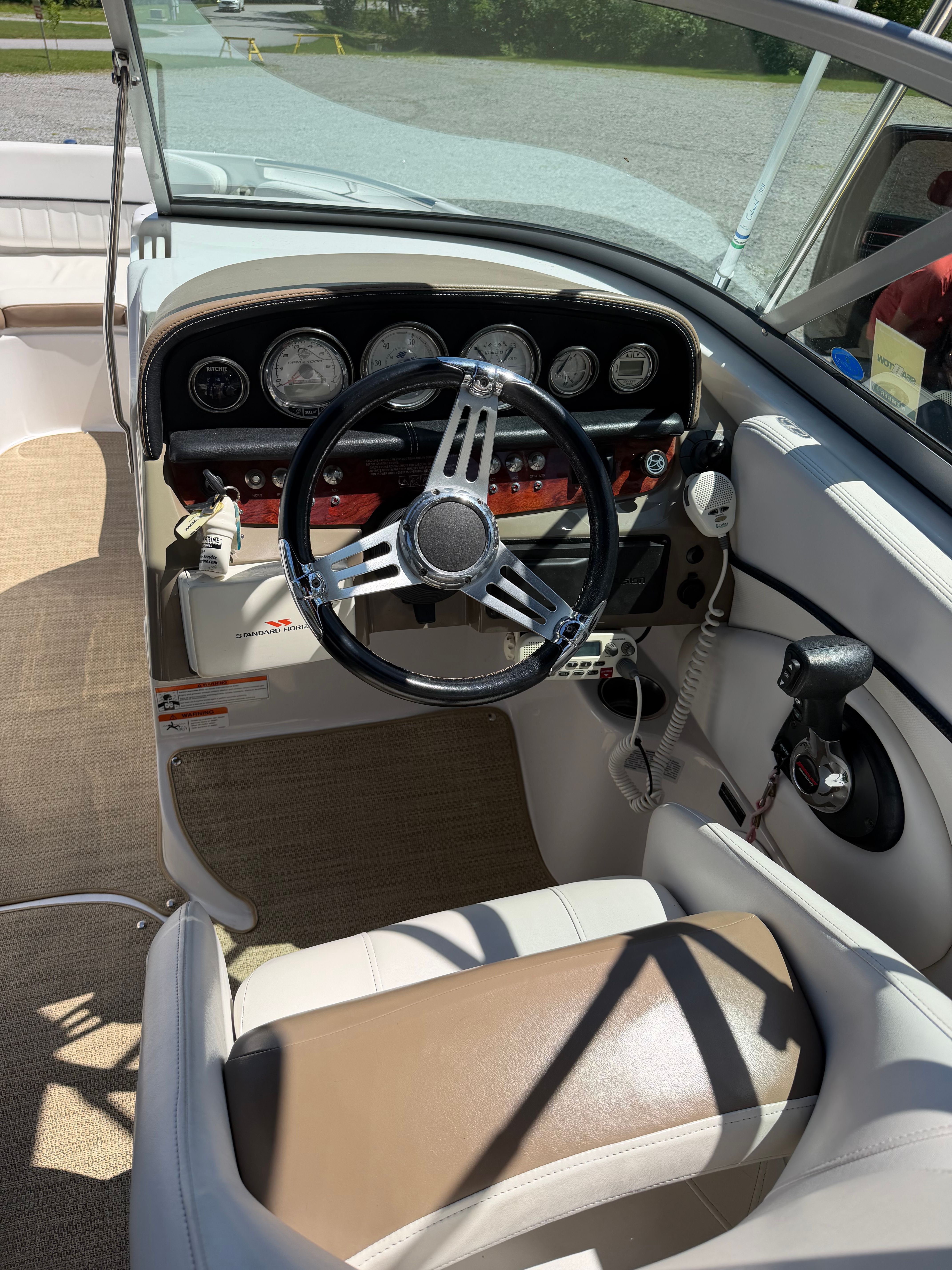 The cockpit of a 2008 Four Winns H240 Frenzy with a sleek steering wheel and dashboard.