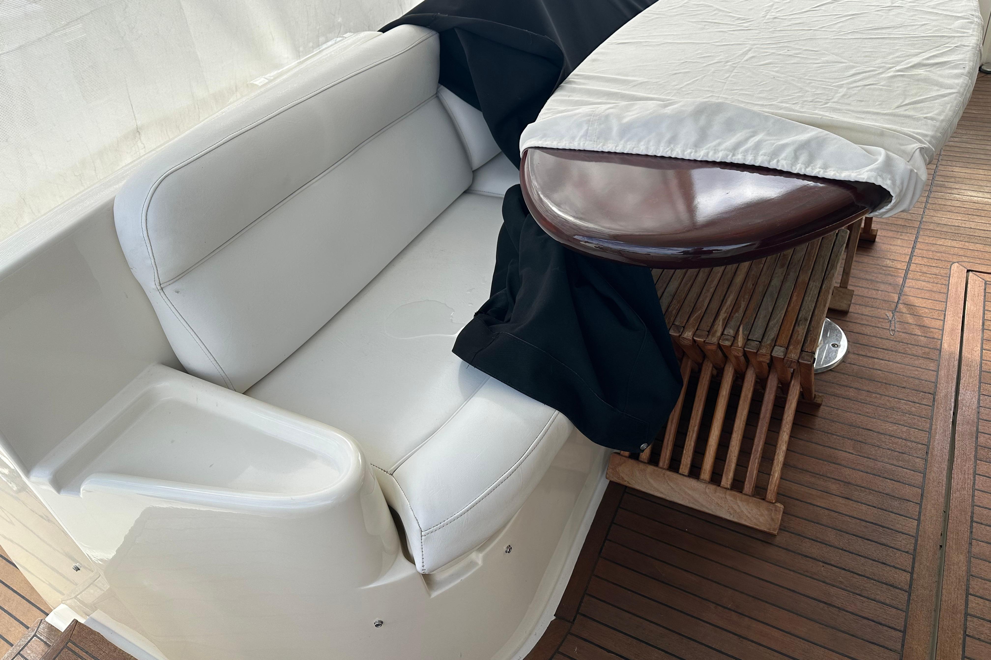 Luxurious seating area on a 2004 Azimut 55E yacht with wooden flooring.