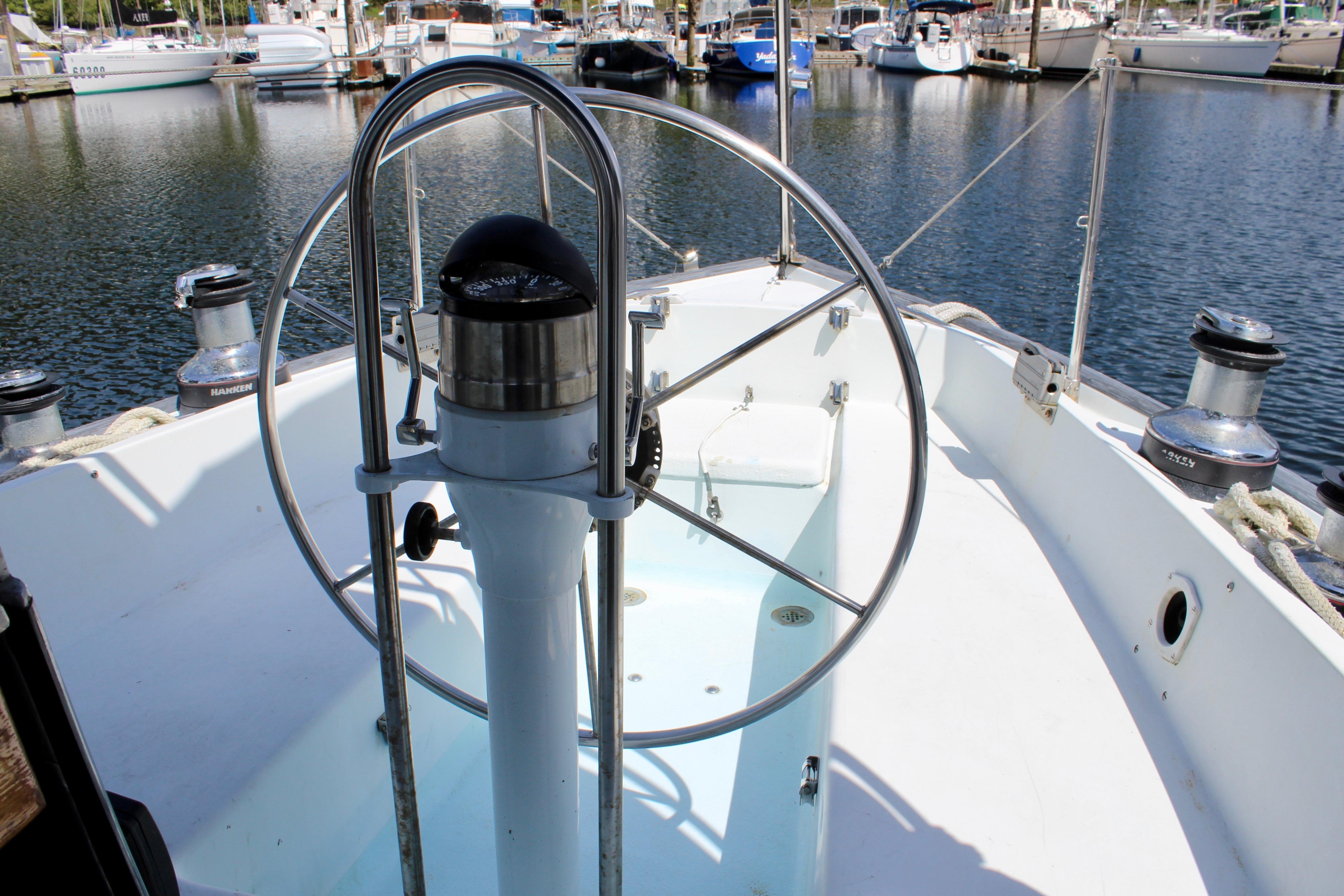 Cockpit of a 1993 Freya 39 sailboat, featuring a steering wheel and marina view.