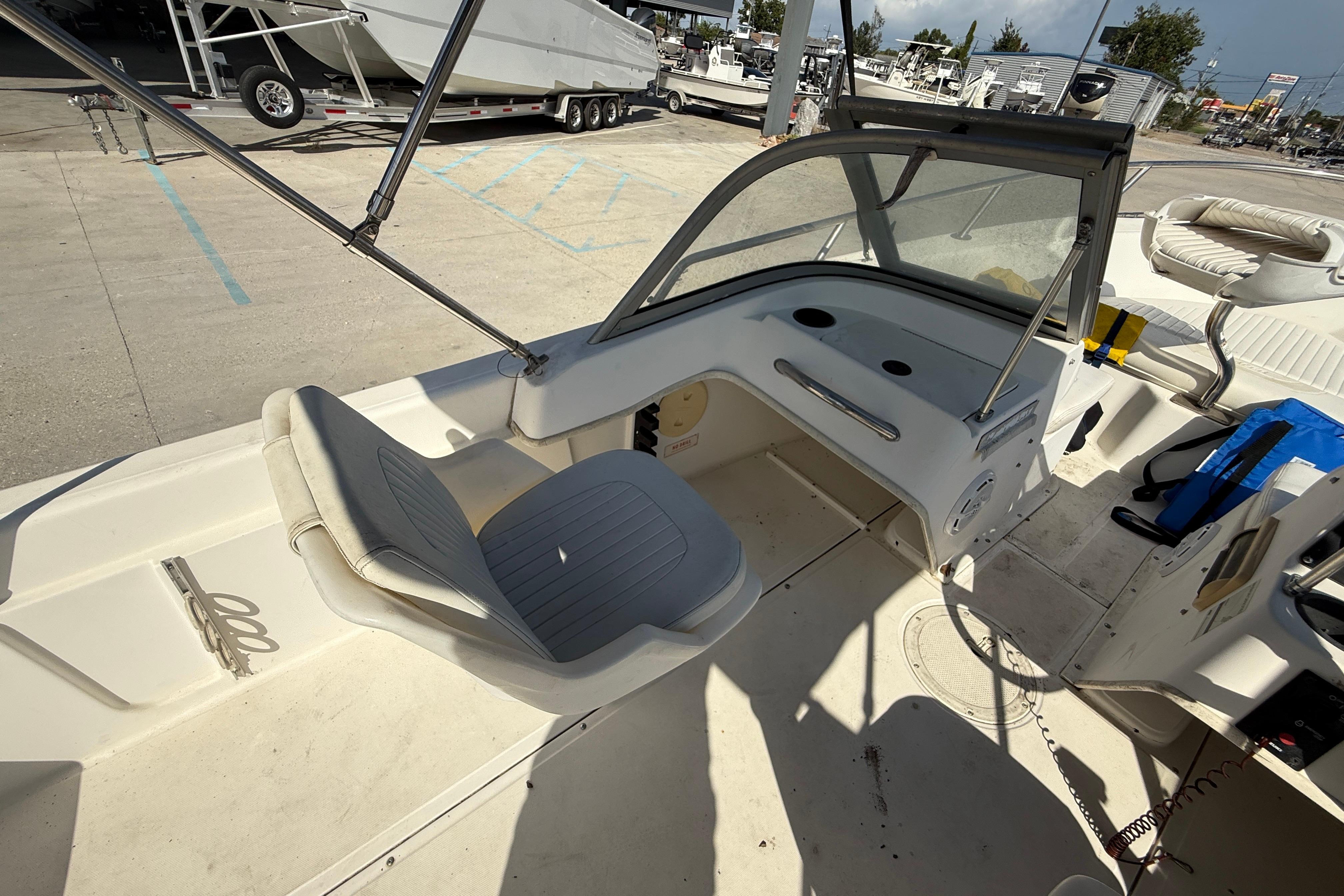 2002 Boston Whaler Ventura 160 interior with seating and dashboard, docked at a marina.