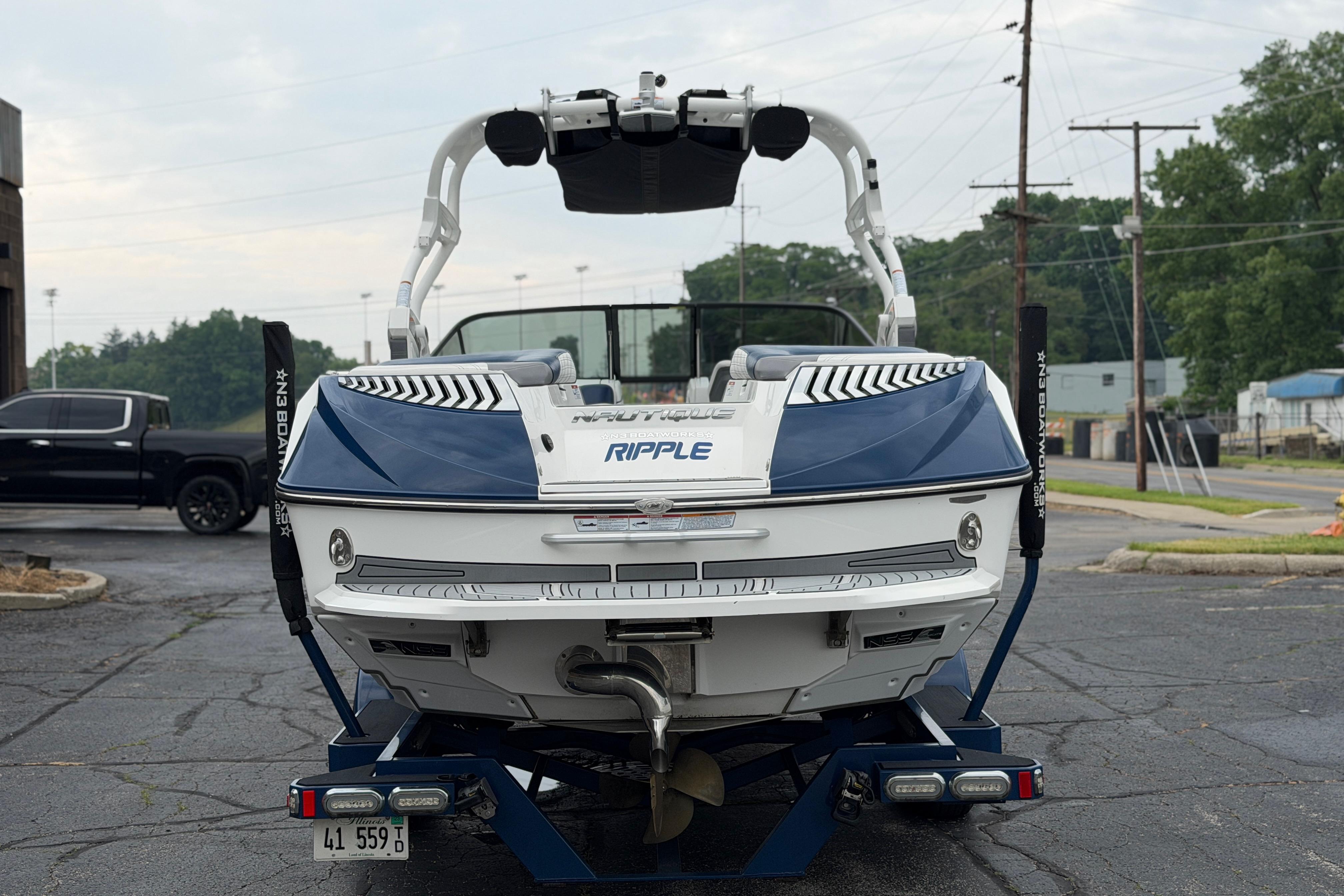 2016 Naitique G25 boat on trailer, rear view, parked outdoors.