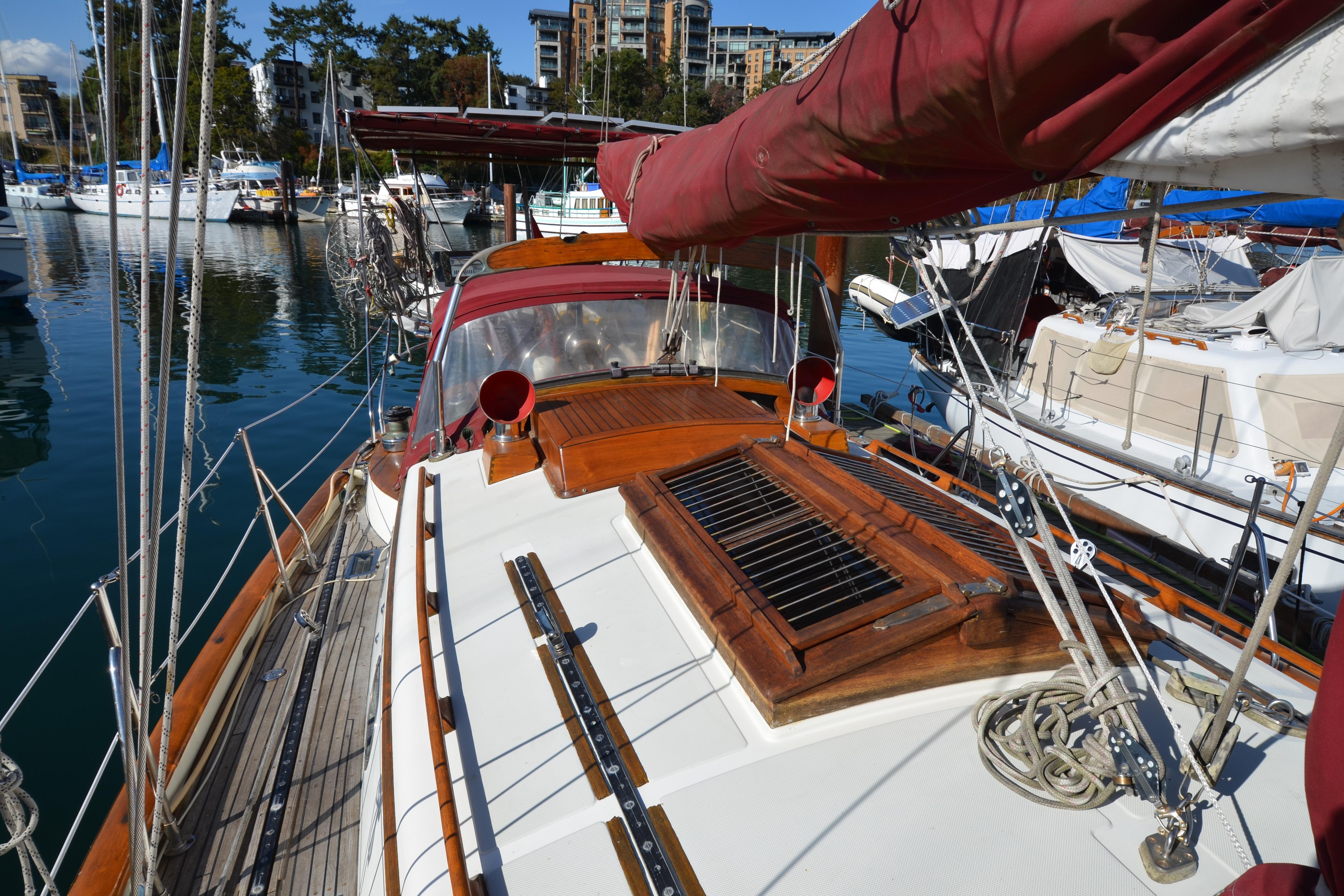 1982 Ta Shing Panada sailboat docked, featuring wooden deck and red sail cover.