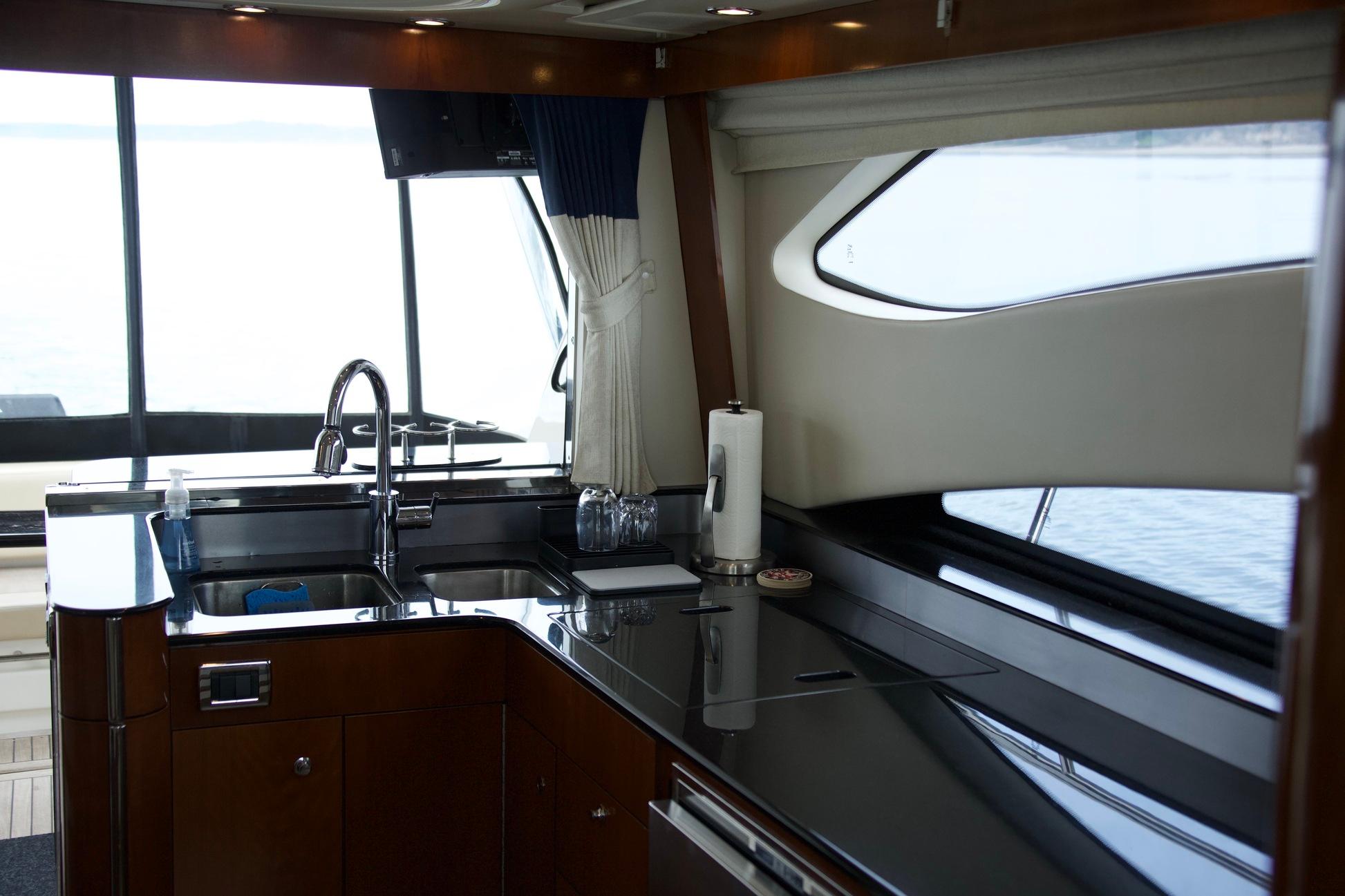 Interior of 2012 Meridian 541 Sedan yacht kitchen with sleek countertops and modern fixtures.