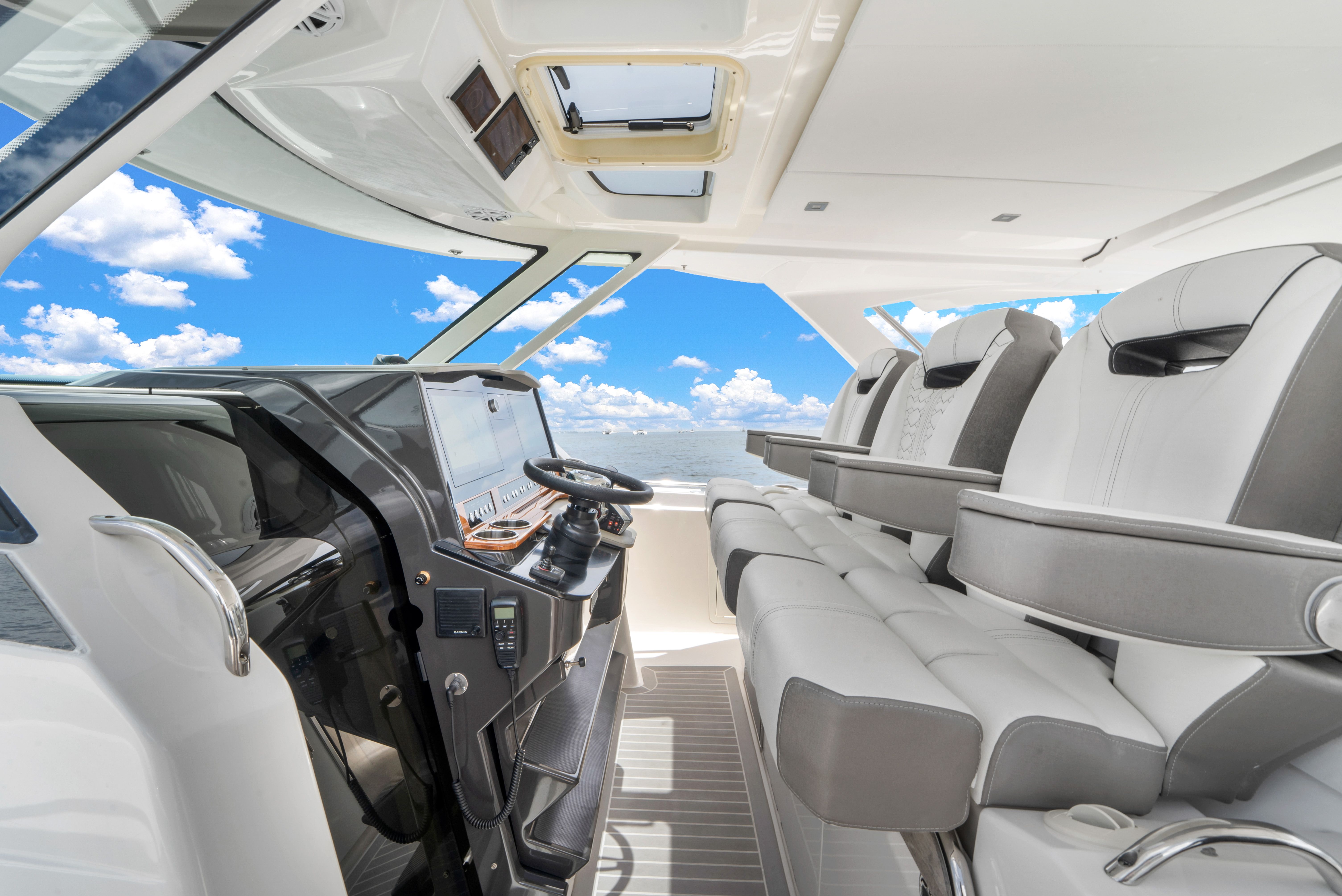 The cockpit of a luxury yacht with modern seating and a clear view of the sky.