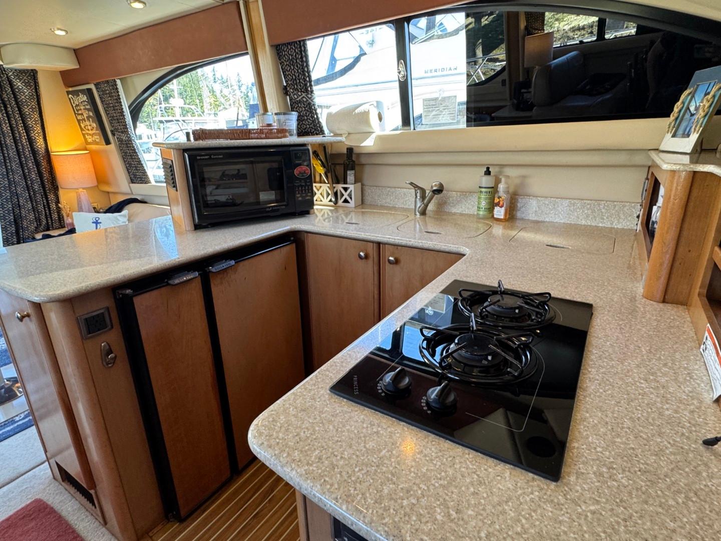 2003 Meridian 381 Sedan kitchen with stove, microwave, and countertop in a cozy interior setting.