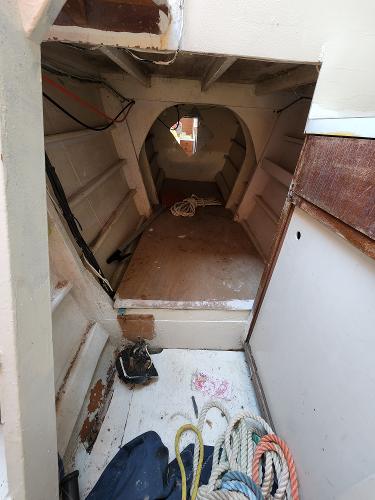 Interior of a 1985 Crowther Buccaneer boat showing storage space and ropes.