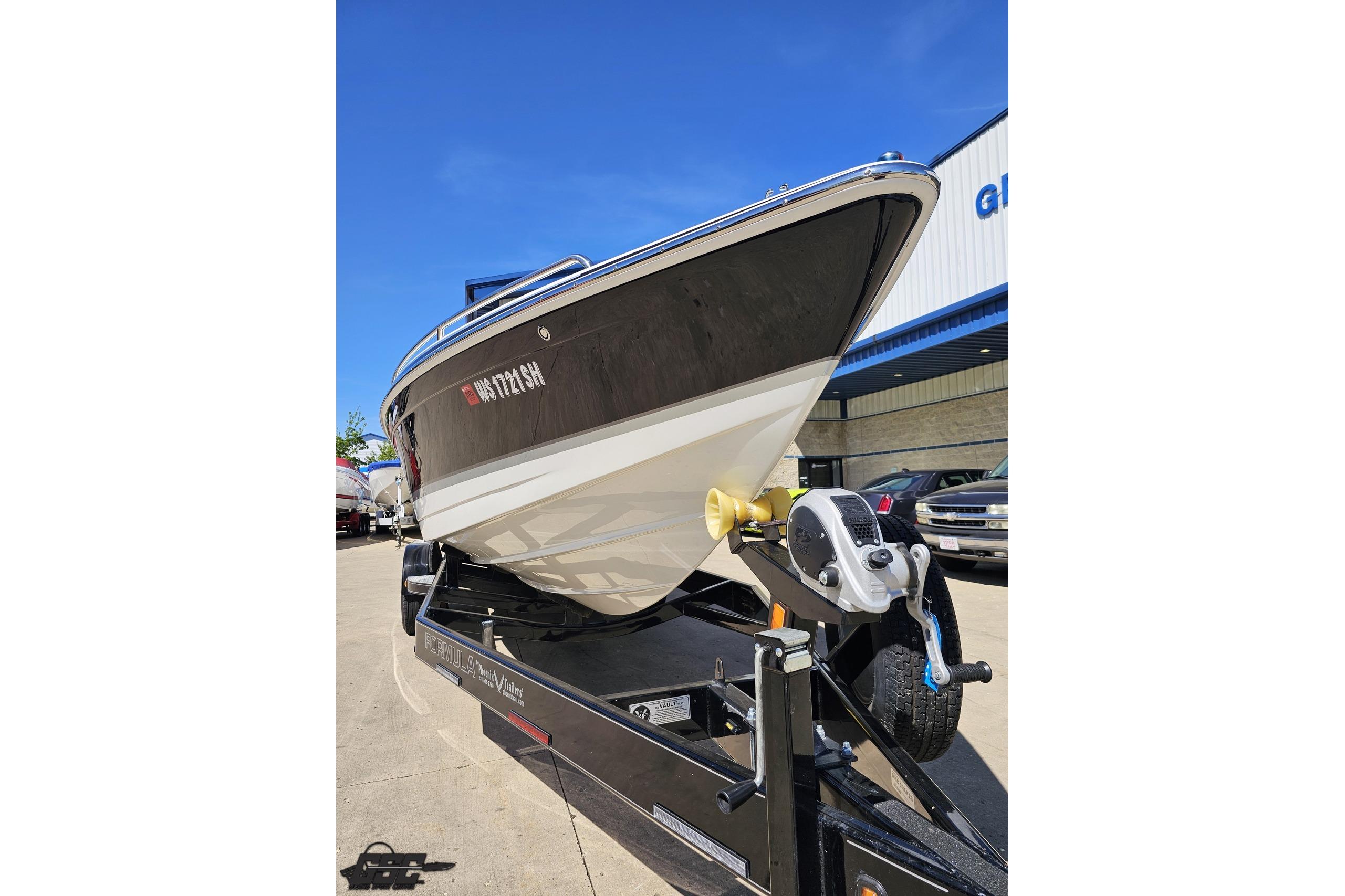 2014 Formula 292 FASTech boat on trailer, parked outdoors under clear blue sky.