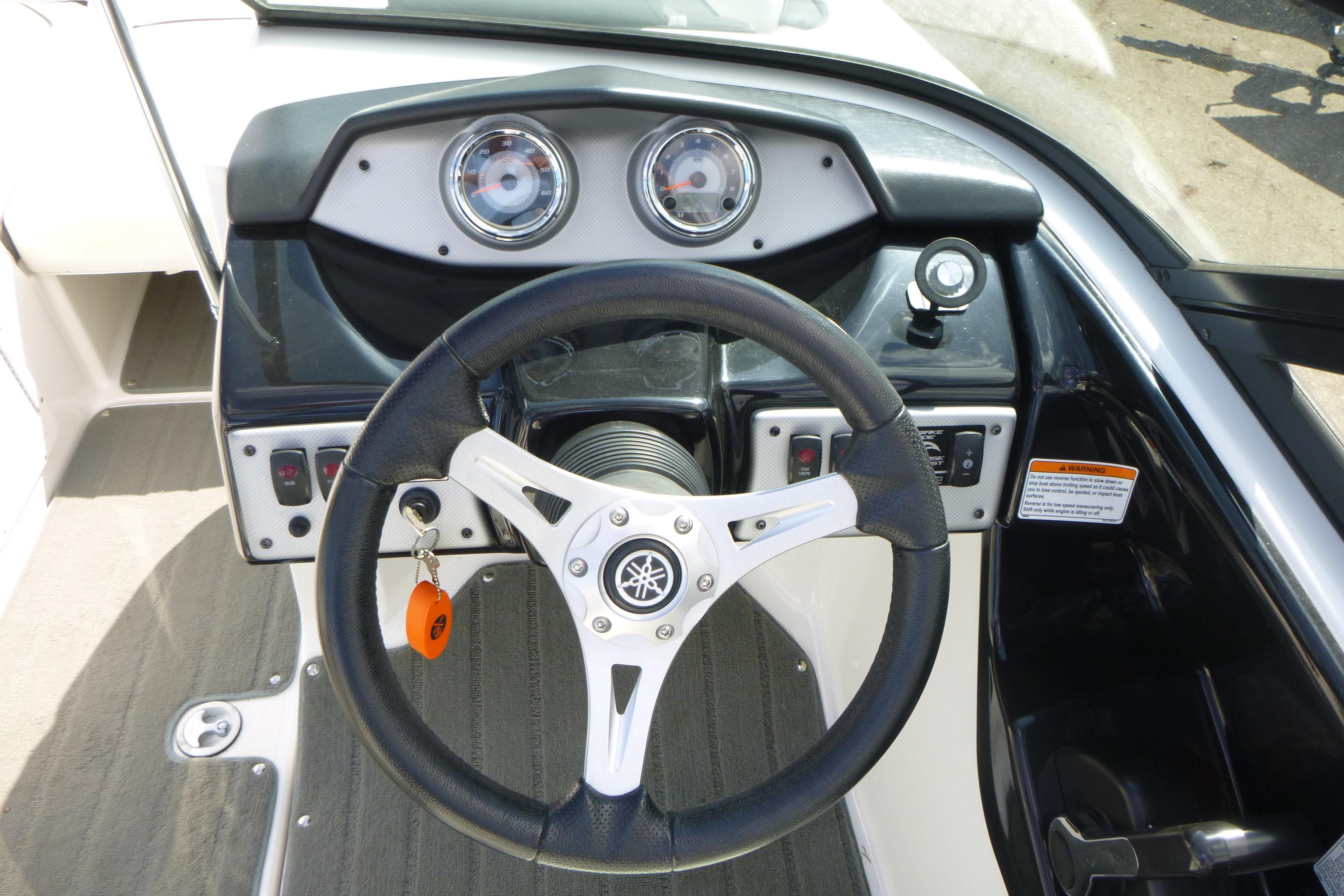 Steering wheel and dashboard of 2015 Yamaha Boats SX192, featuring gauges and controls.