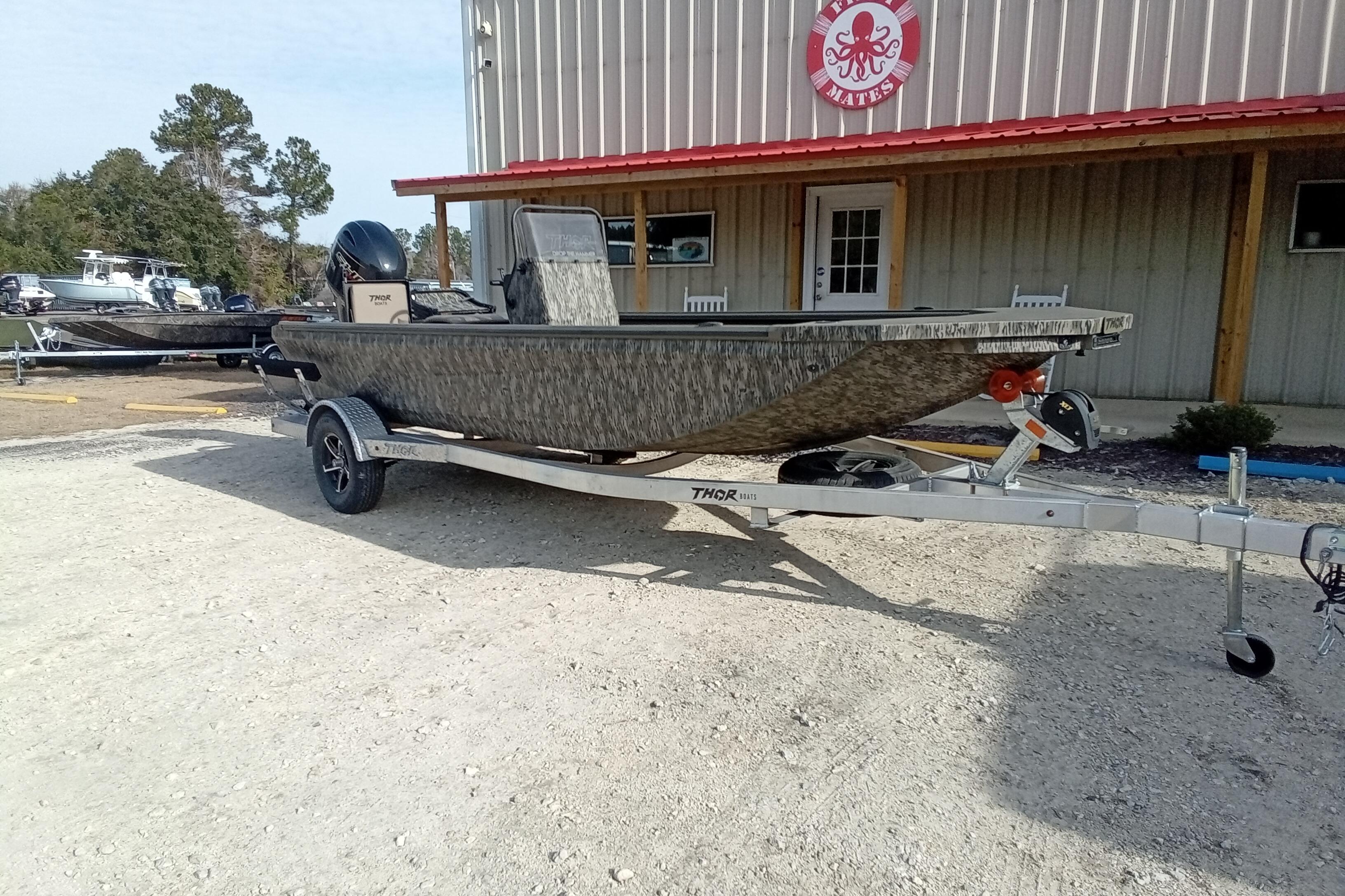 2026 Thor 1900 Low Country Elite boat on trailer outside a building.