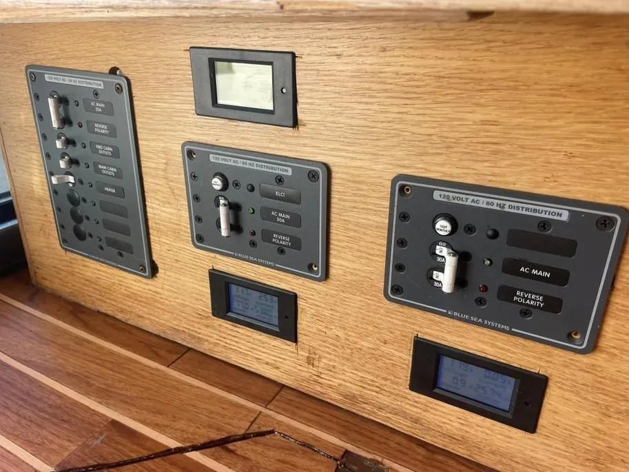 Control panel of a 1985 Princess Sedan Flybridge boat with wooden finish and electrical switches.