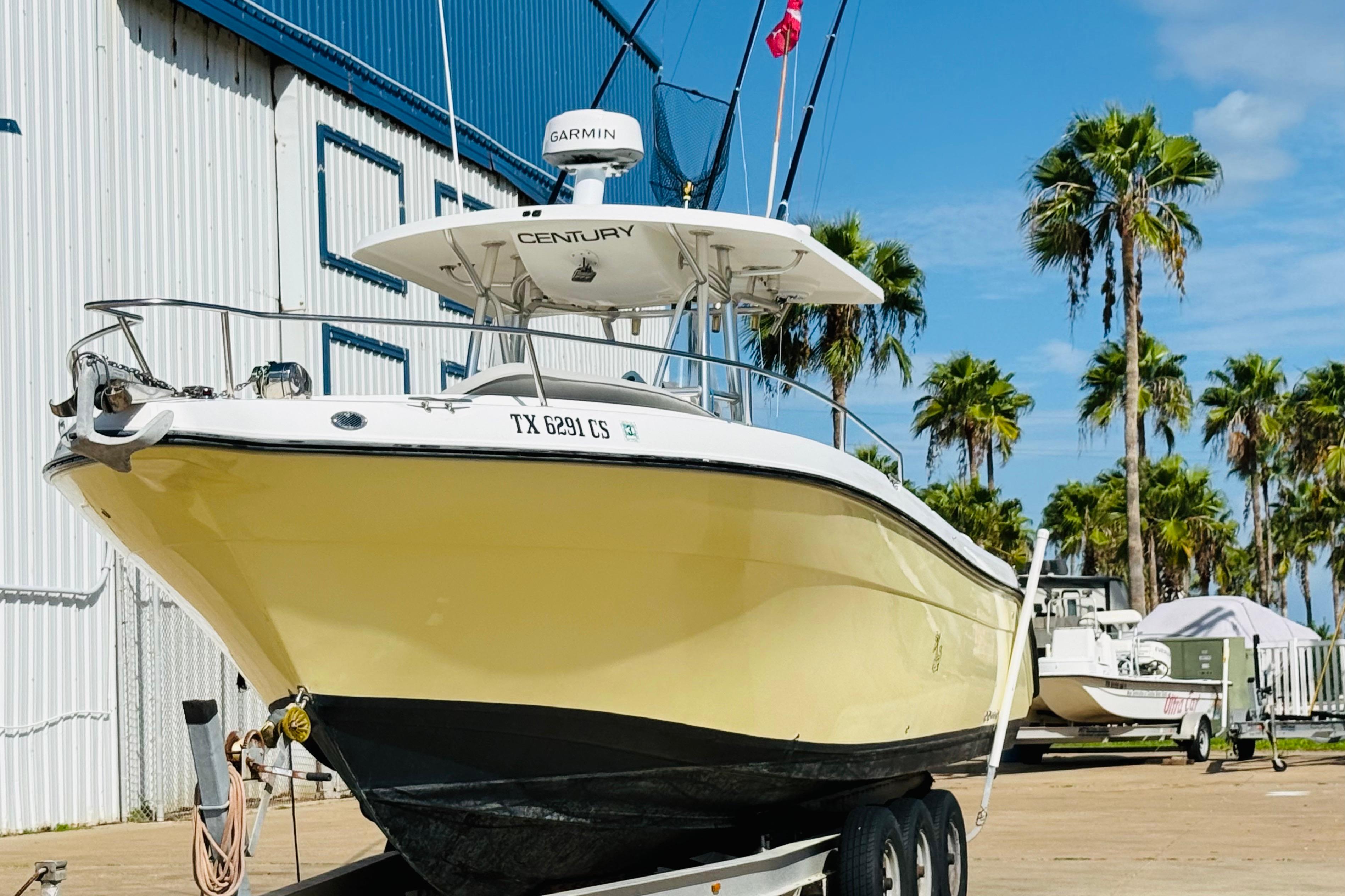 2005 Century 3200 Center Console boat on trailer, palm trees in background.