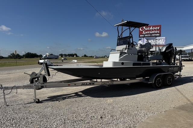 2025 Majek 24 Reaper boat on trailer at outdoor dealership under clear sky.