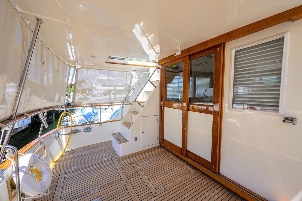 Spacious deck of 1999 Grand Banks 42 Europa yacht with wooden flooring and elegant design.