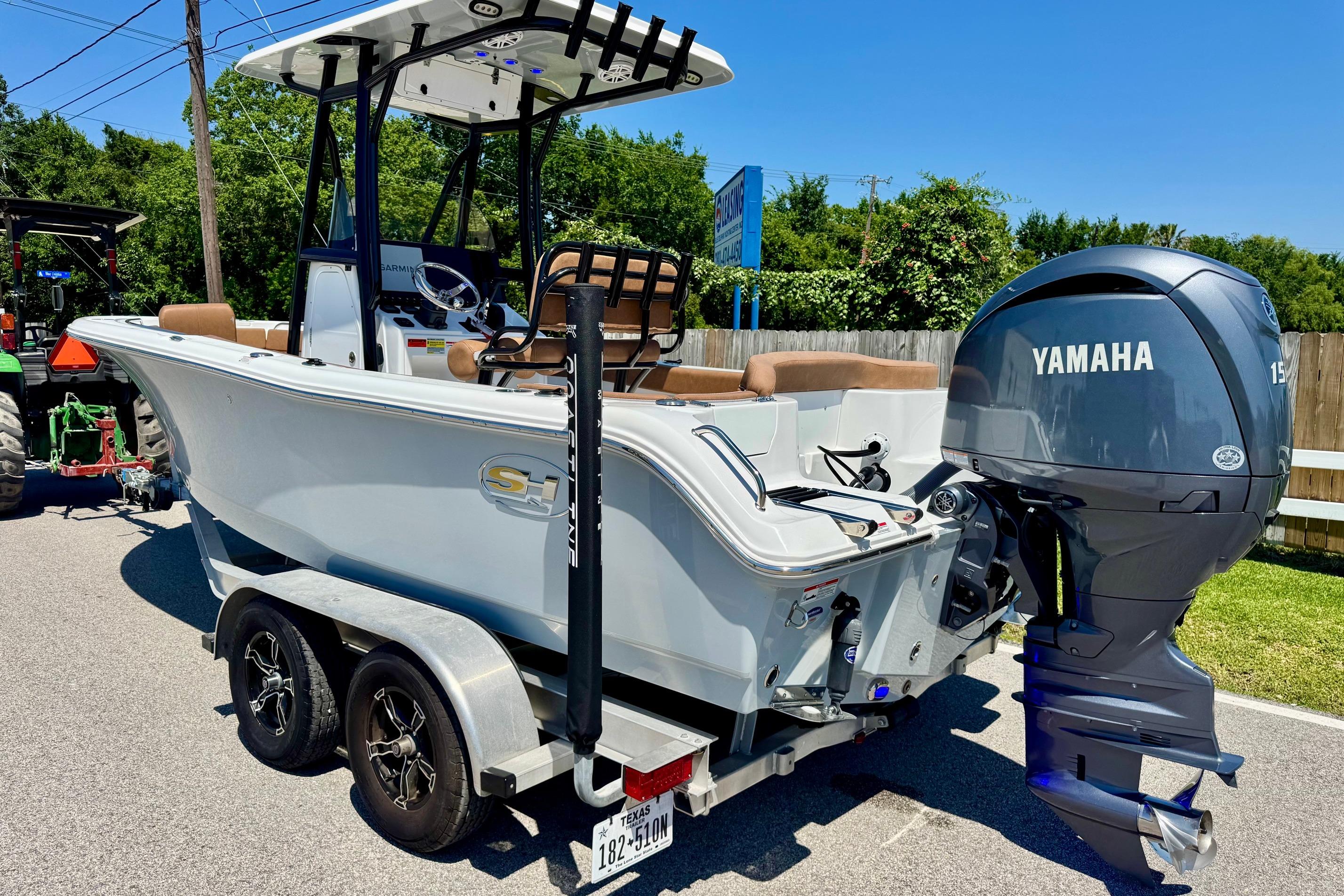 2025 Sea Hunt Ultra 219 boat with Yamaha engine on a trailer, parked outdoors.