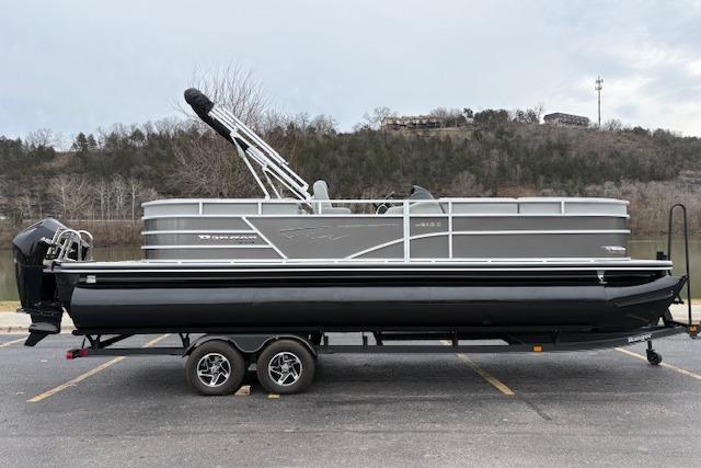 2025 Ranger Reata 243C pontoon boat on trailer, parked in scenic outdoor setting.