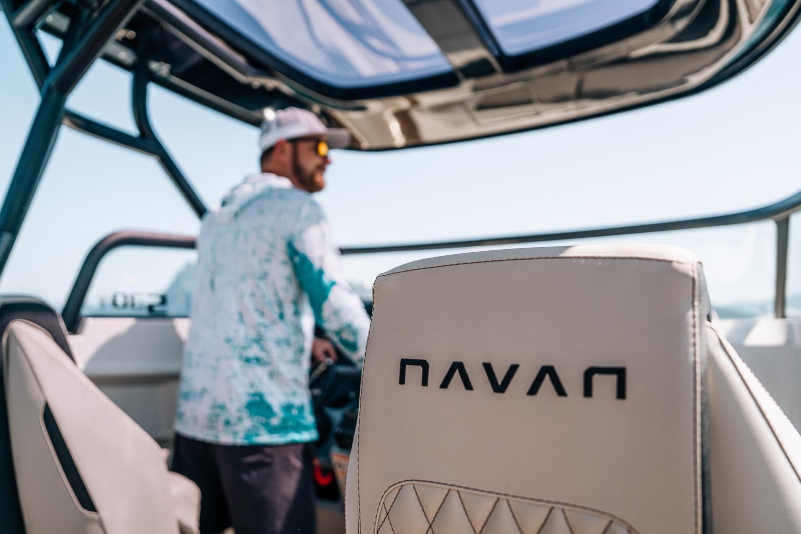 Man steering 2026 Navan S30 boat, focus on branded seat.