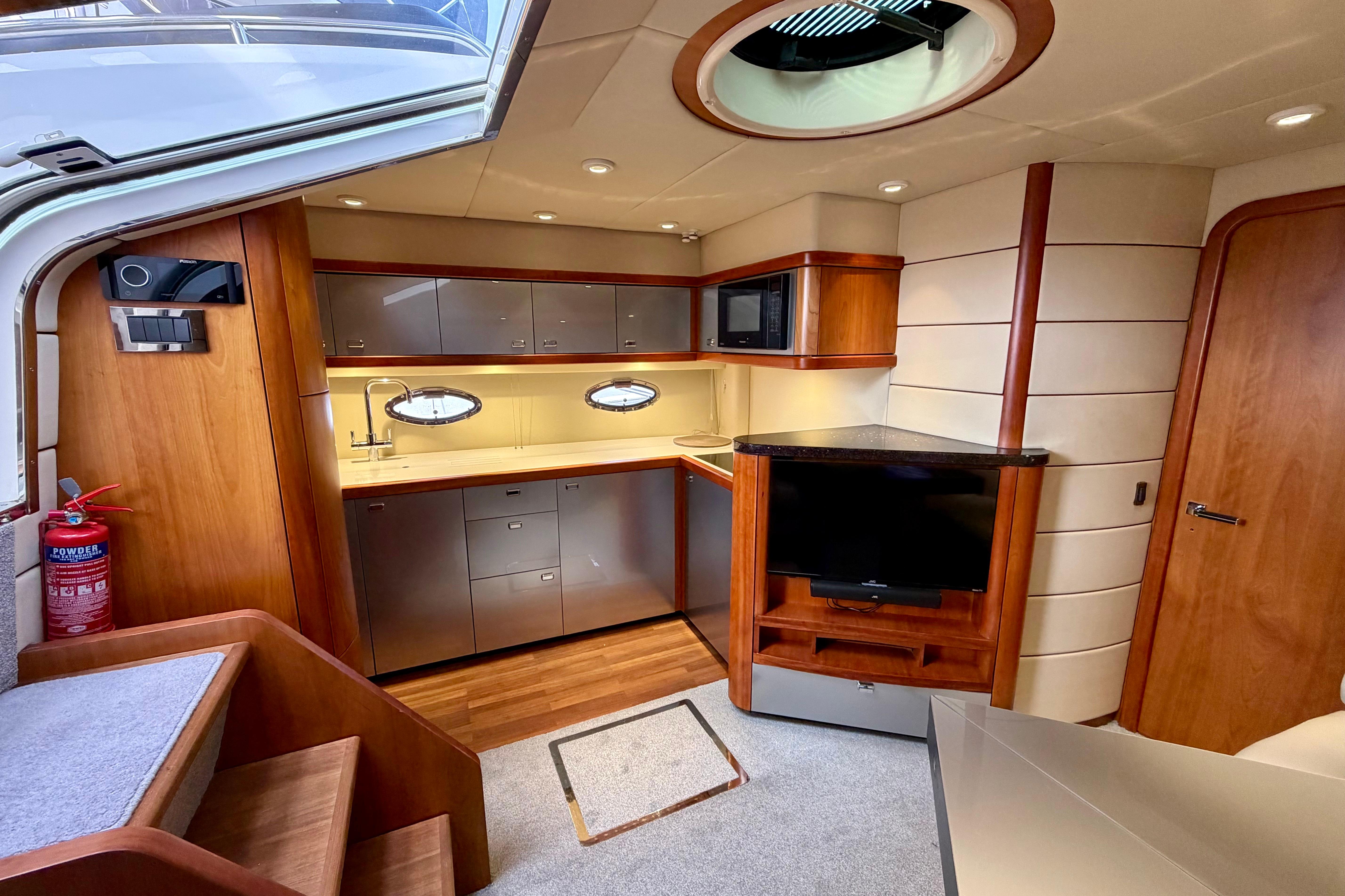 Luxurious interior of 2007 Sunseeker Portofino 47 yacht with modern kitchen and entertainment area.