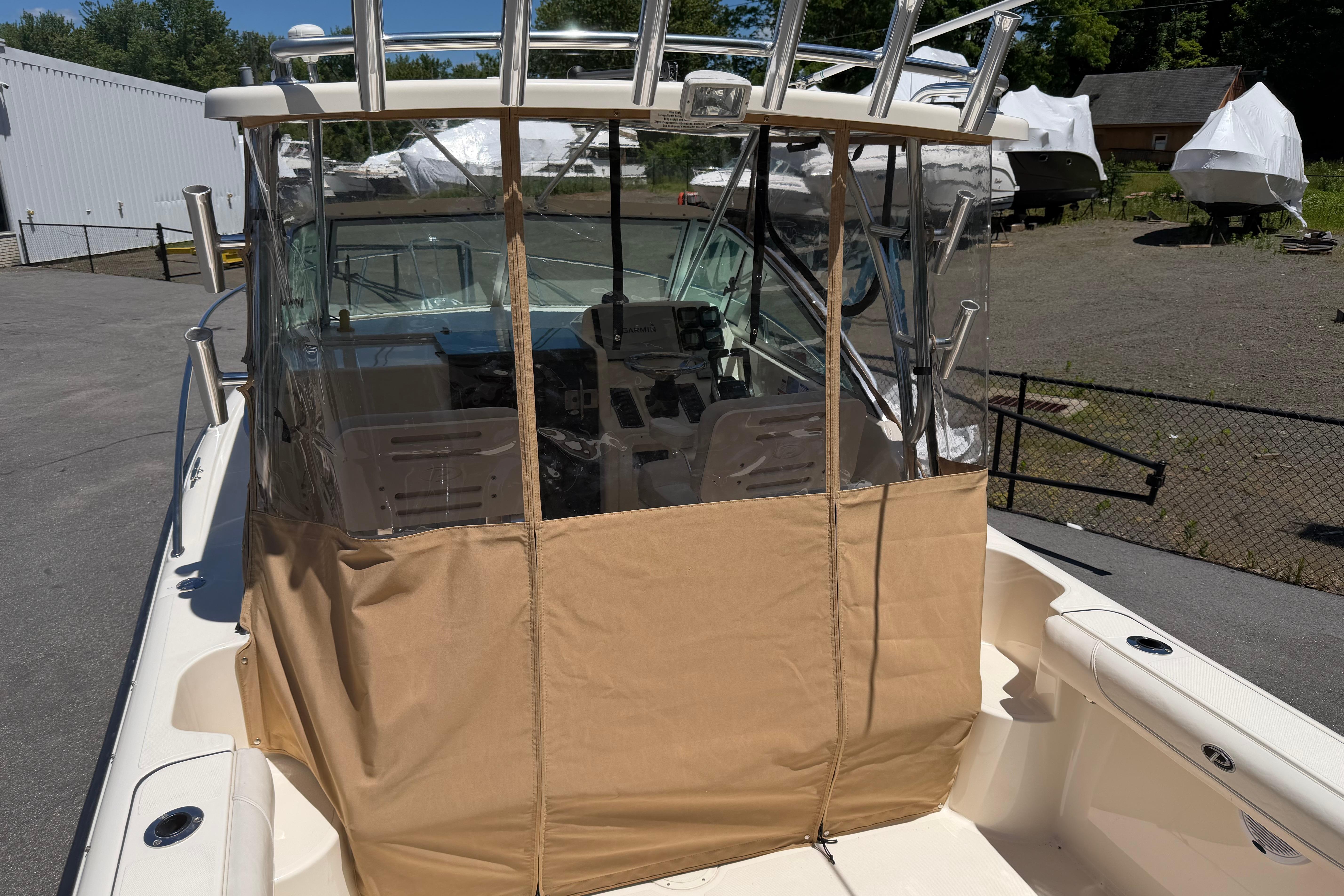 2010 Pursuit OS 255 Offshore boat with protective cover, docked outdoors.