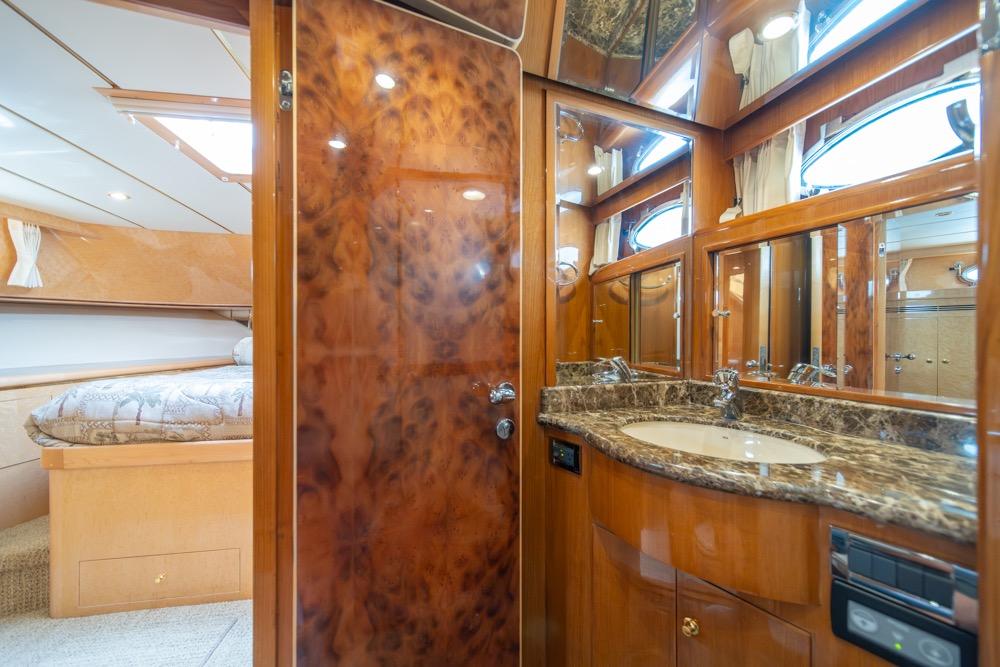 Luxurious bathroom and bedroom interior of 2005 Ocean Alexander 64 Motoryacht, featuring wood finishes.